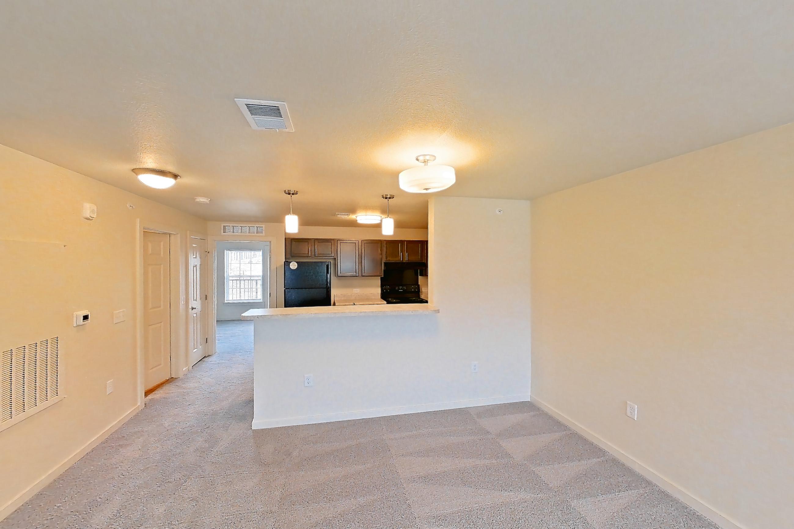 Living space with black appliances, electric range, light carpet, oven/range, and refrigerator, Apartment 2D at The Creek at Cottonwood