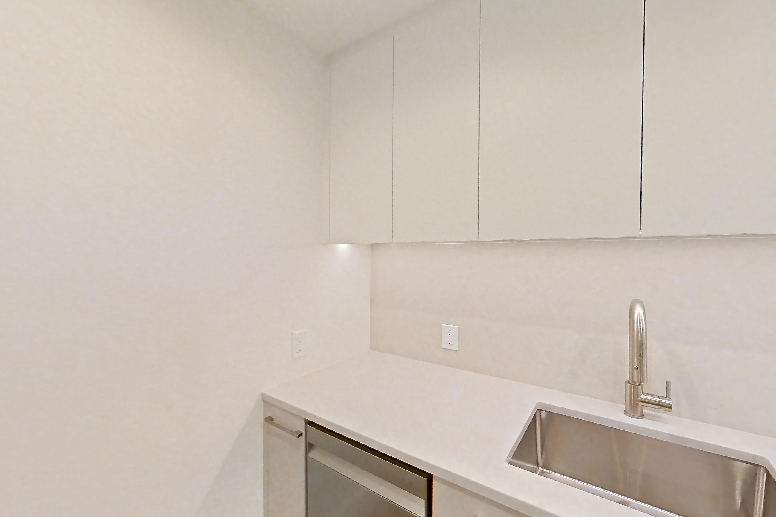 Kitchen with dishwasher, gas range, light countertops, light stone countertops, light wood-finish flooring, oven/range, refrigerator, and stainless steel appliances, Apartment 37L at Lumen