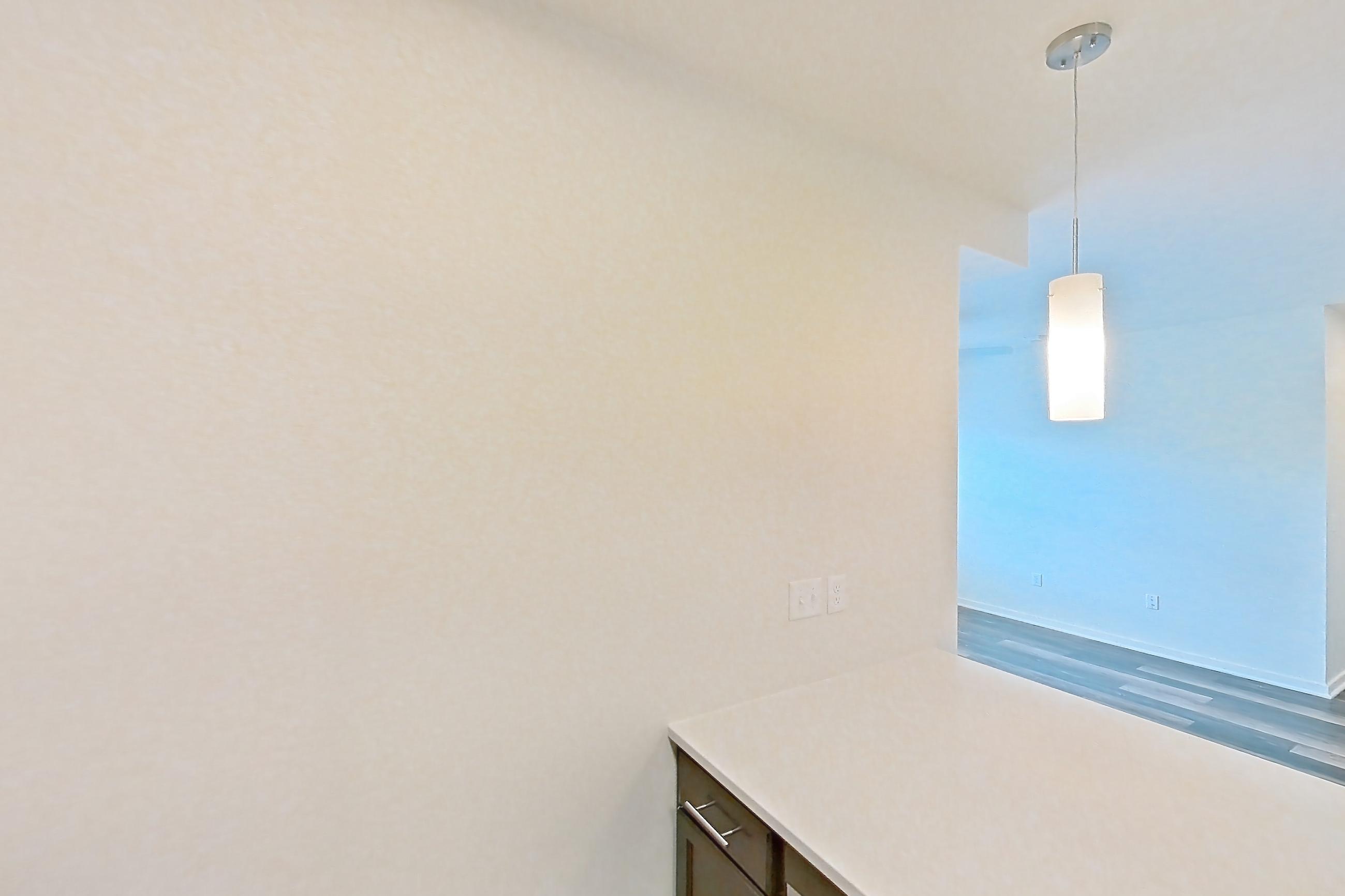 Kitchen with black appliances, dark wood-finish flooring, dishwasher, electric range, light countertops, microwave, oven/range, refrigerator, and stainless steel appliances, Apartment 3204 at Village at Thorncreek