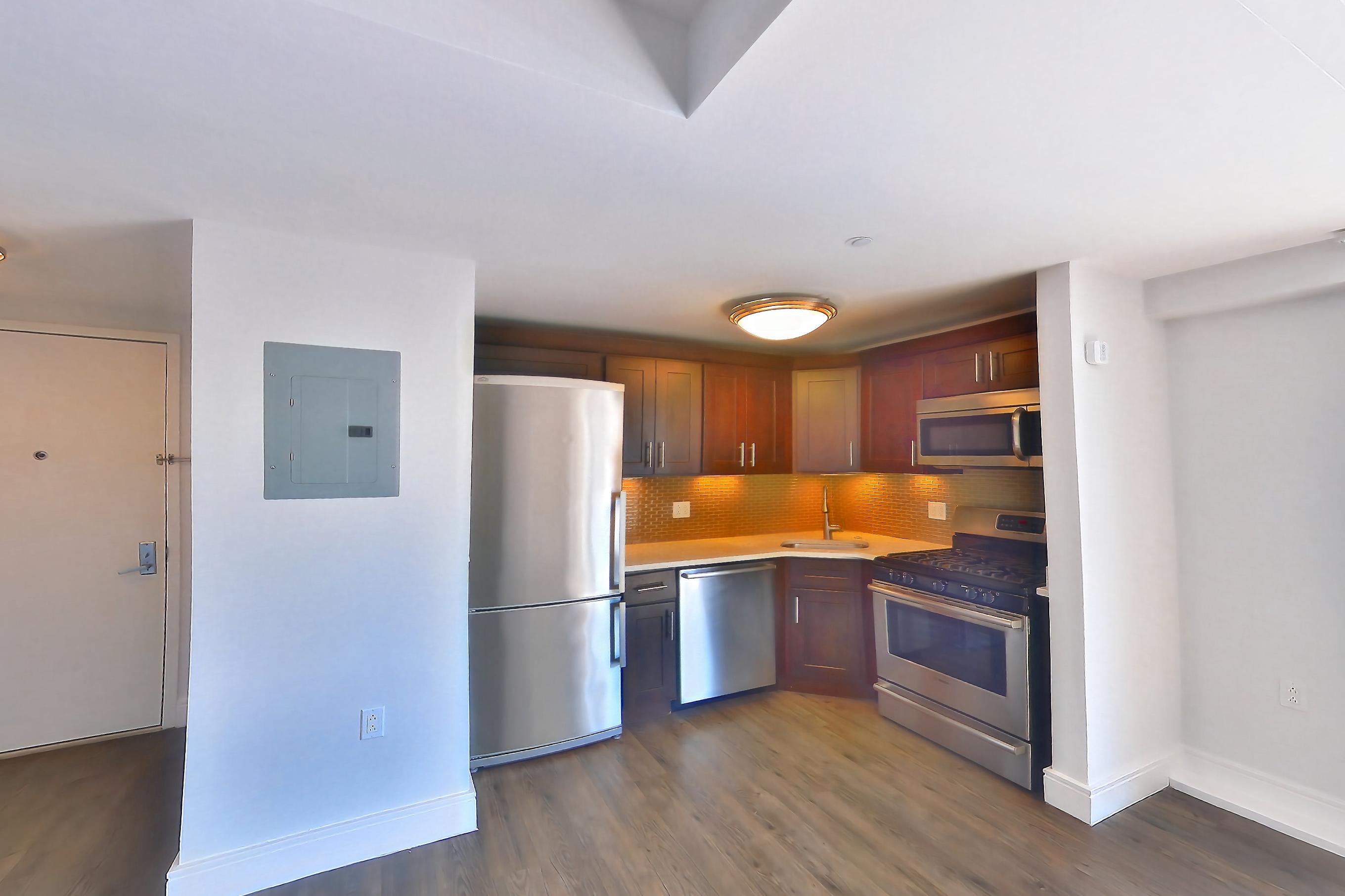 Living room with dark wood-finish flooring, dishwasher, gas range, light countertops, oven/range, refrigerator, and stainless steel appliances, Apartment 1401 at Stonehenge Leasing