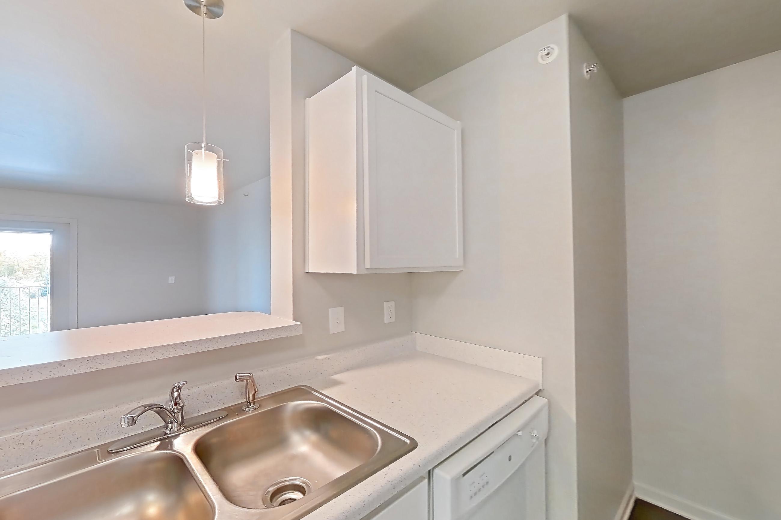 Kitchen with dark wood-finish flooring, dishwasher, electric range, light countertops, oven/range, refrigerator, white appliances, and wood-finish flooring, Apartment 111 at Sunset View