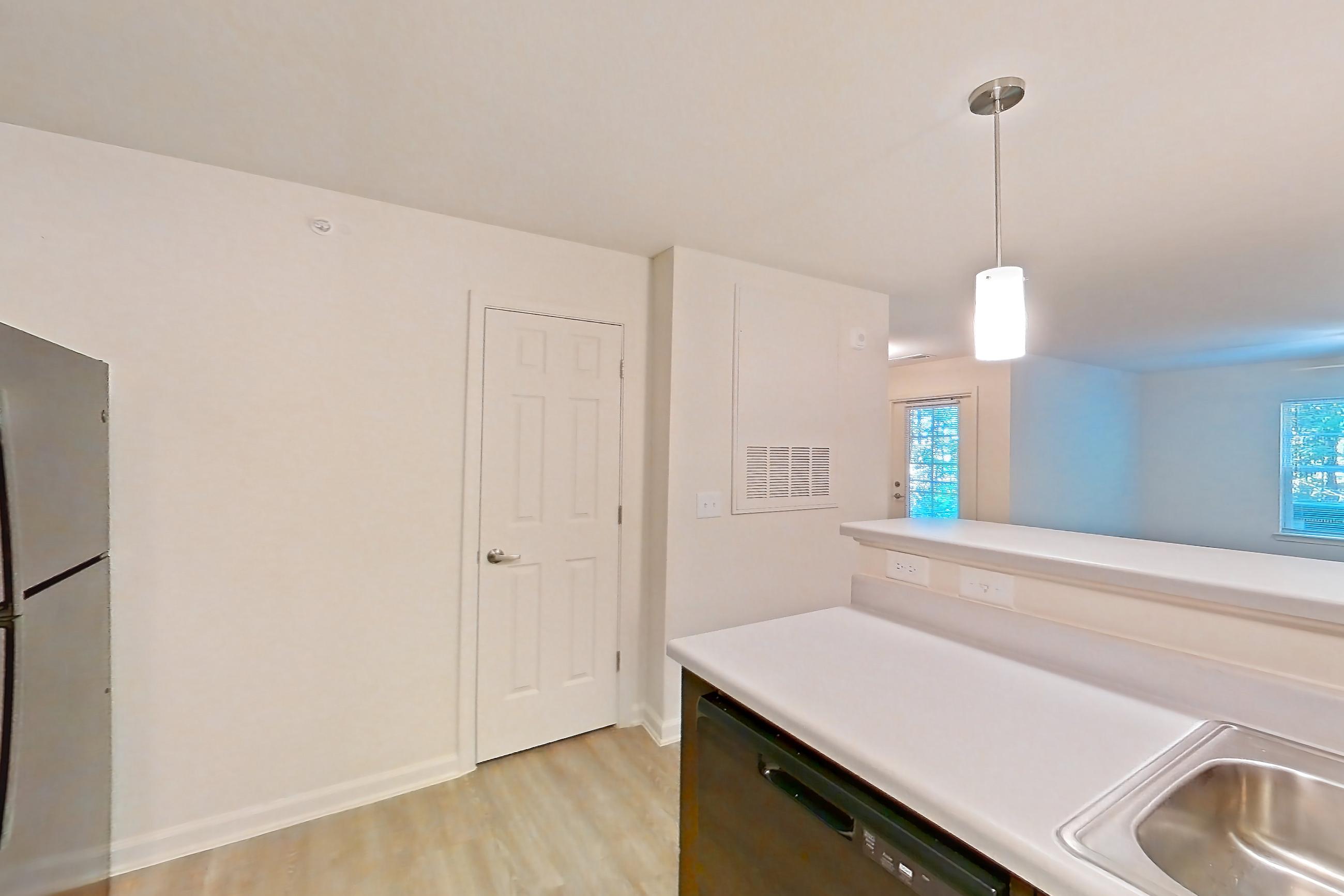 Kitchen with black appliances, dishwasher, electric range, light countertops, light wood-finish flooring, oven/range, and refrigerator, Apartment 3002 at Ivy Ridge