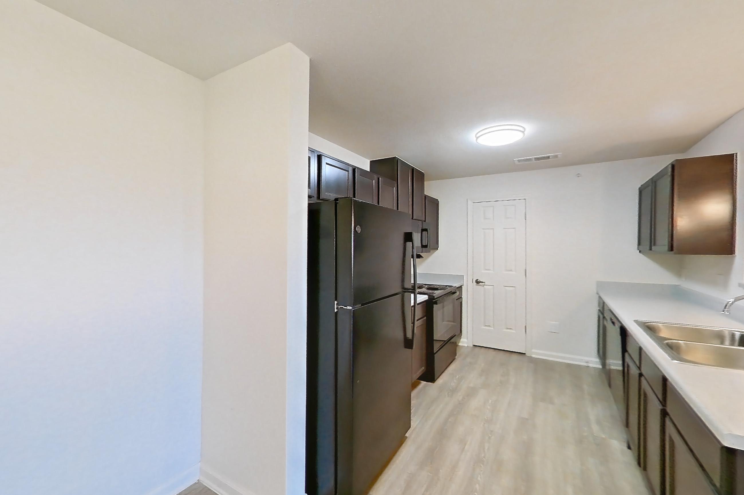 Dining room with black appliances, electric range, light countertops, light wood-finish flooring, oven/range, and refrigerator, Apartment 7206 at Ivy Ridge