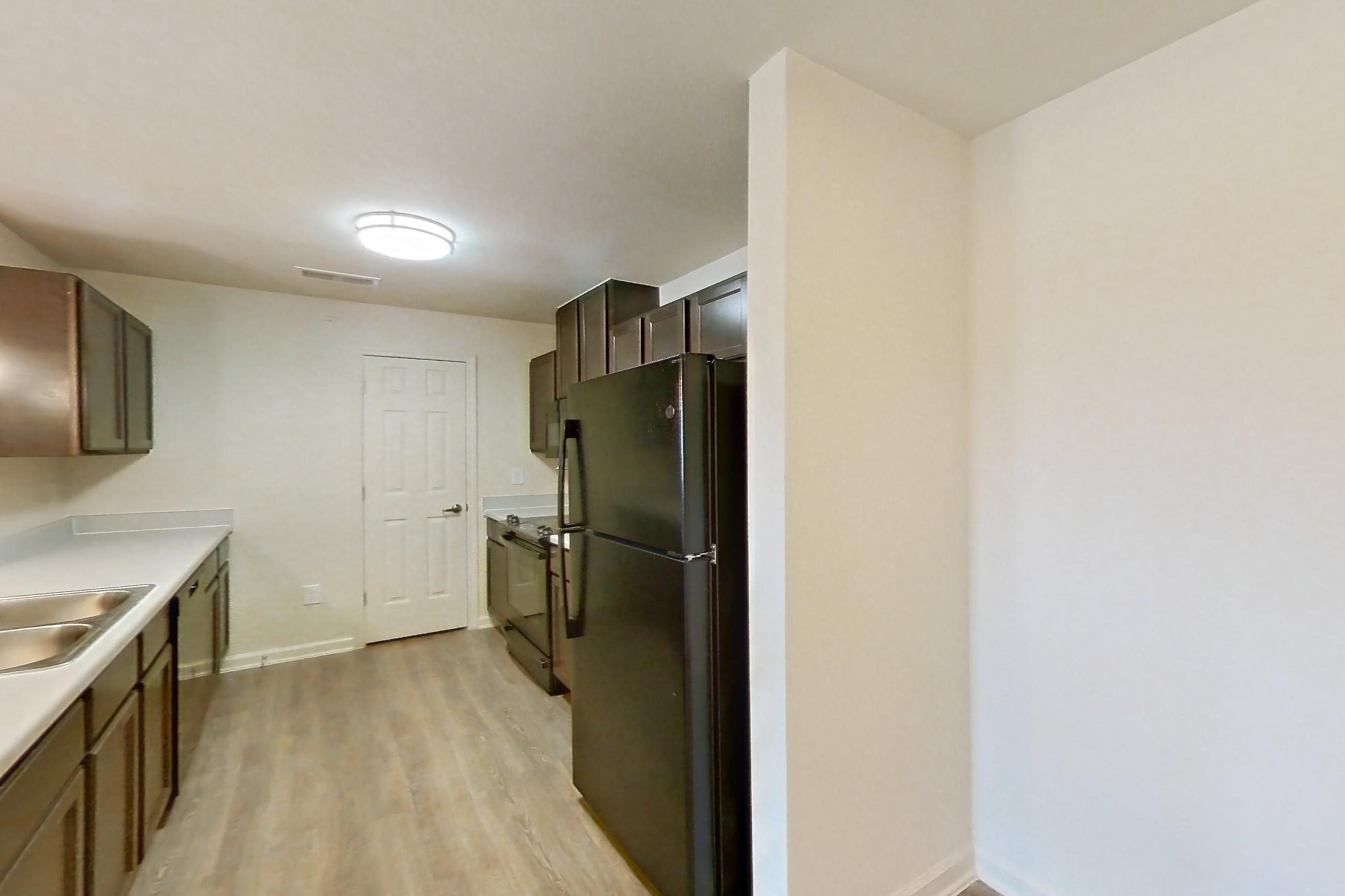 Dining room with black appliances, light countertops, light wood-finish flooring, oven/range, and refrigerator, Apartment 10201 at Ivy Ridge