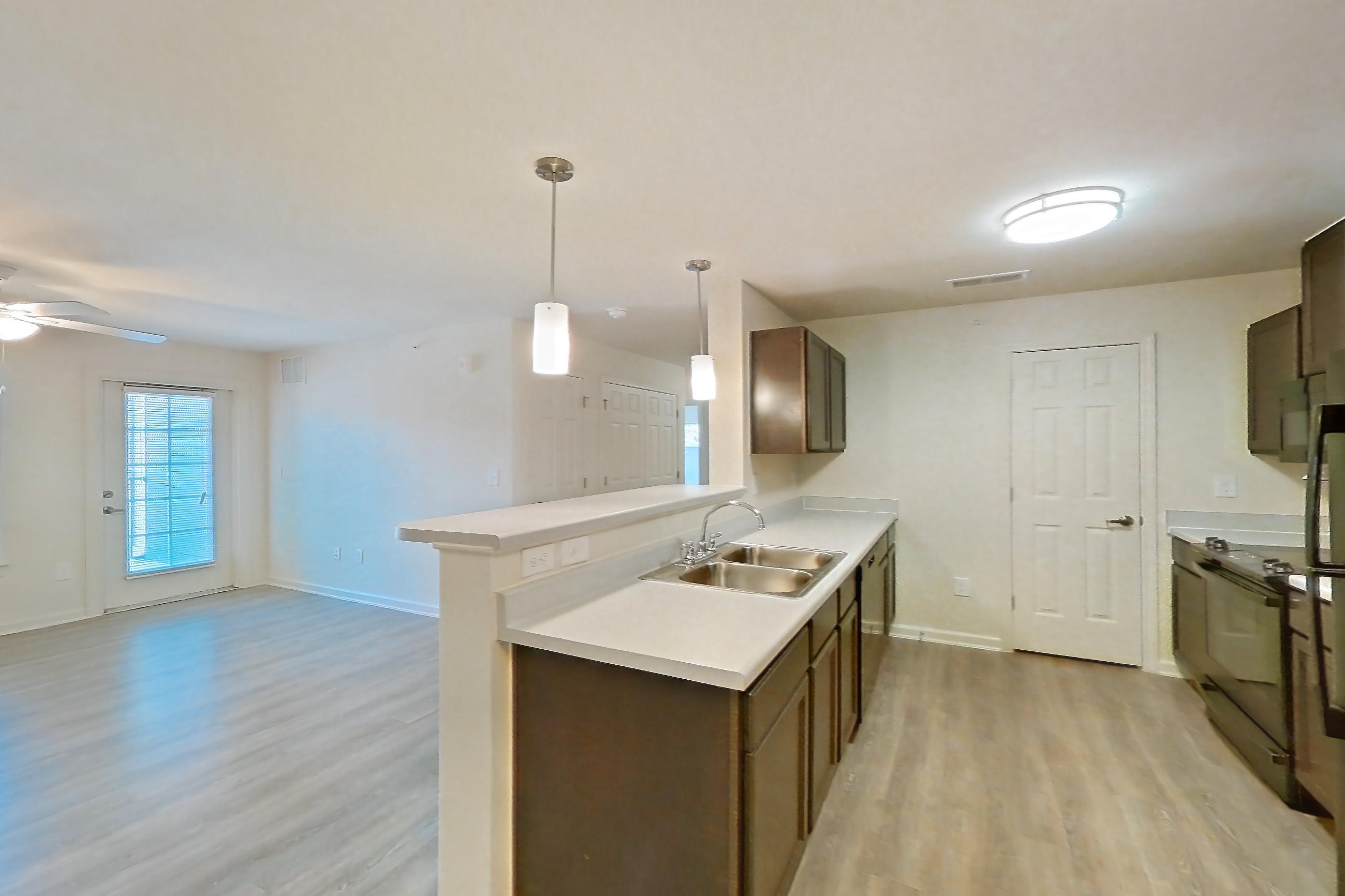 Dining room with black appliances, light countertops, light wood-finish flooring, oven/range, and refrigerator, Apartment 10201 at Ivy Ridge