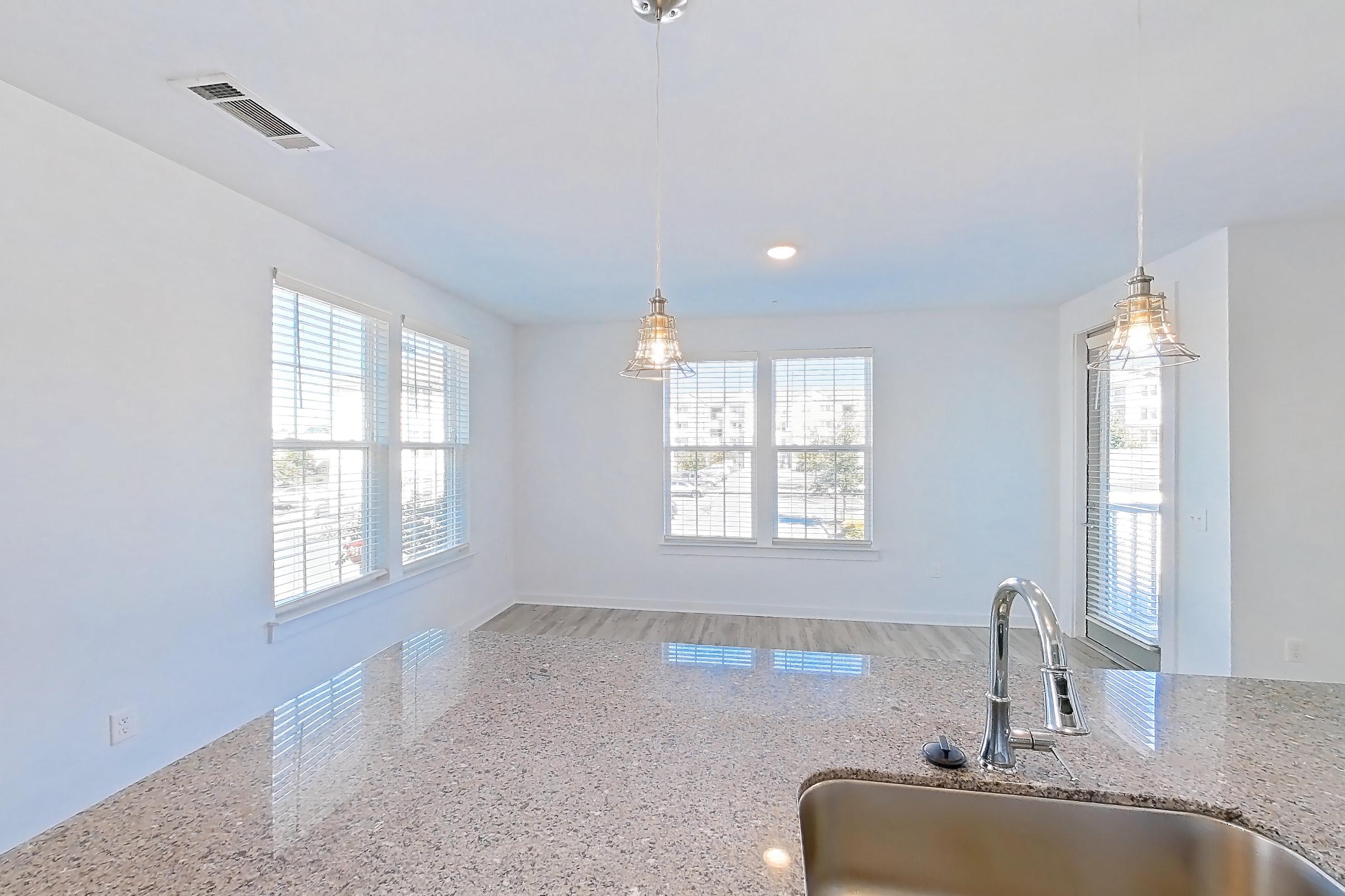 Kitchen with dishwasher, light stone countertops, light wood-finish flooring, oven/range, and stainless steel appliances, Apartment 1048-206 at Avril Cambridge Village