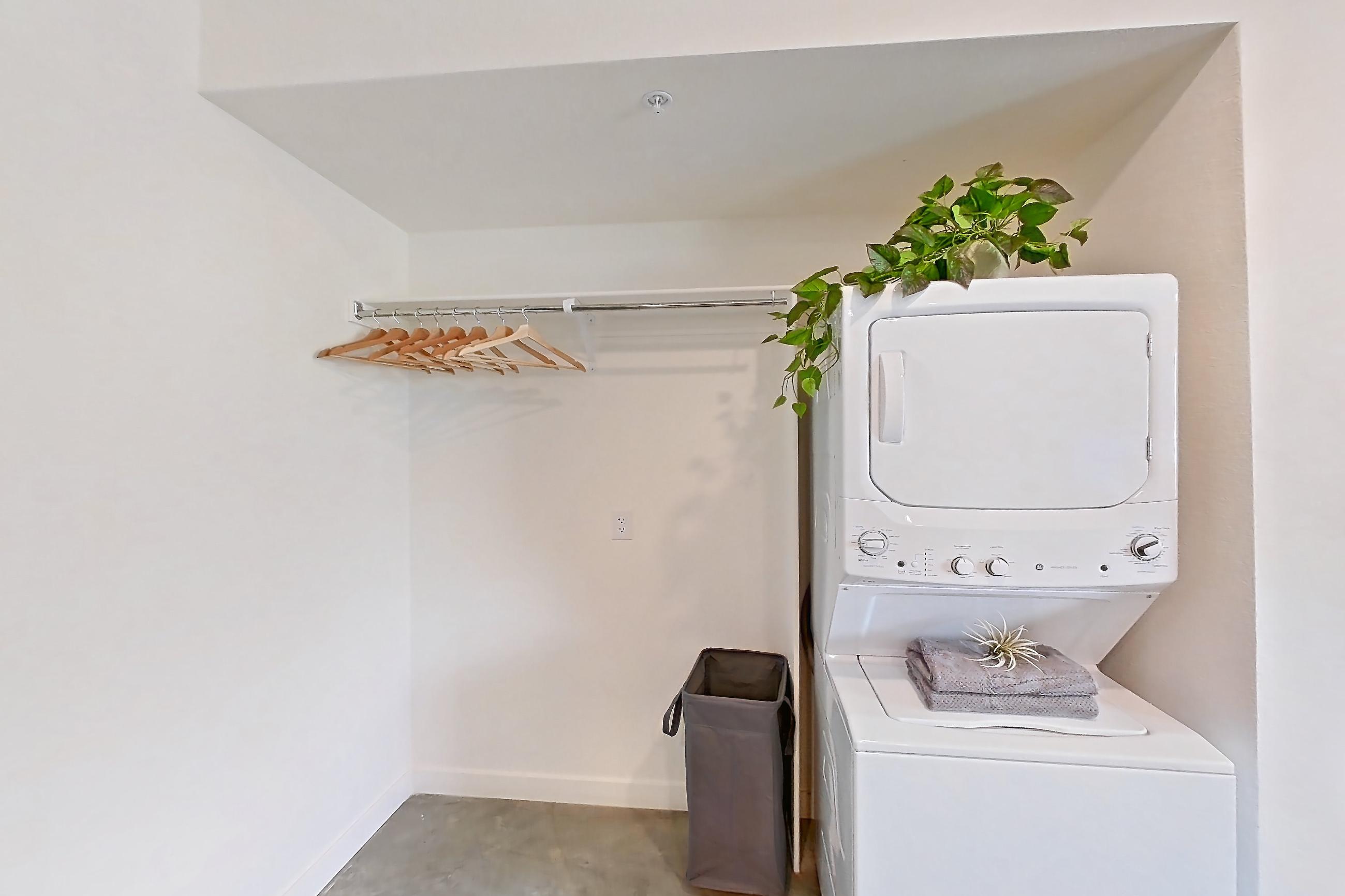Dining room with in-unit laundry, light concrete flooring, polished concrete flooring, refrigerator, and white appliances, Apartment 2002 at Dwell @ 5th and Farmer