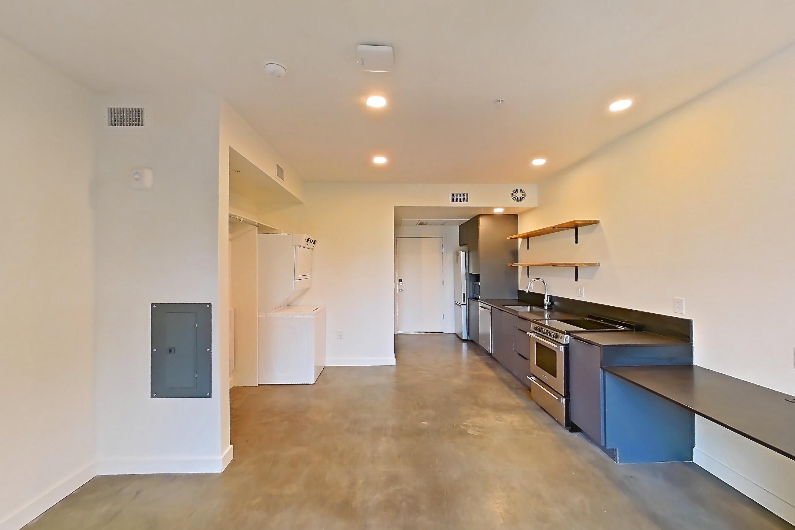Living space with dark concrete flooring, dark countertops, dishwasher, electric range, oven/range, polished concrete flooring, refrigerator, and stainless steel appliances, Apartment 2060 at Dwell @ 5th and Farmer