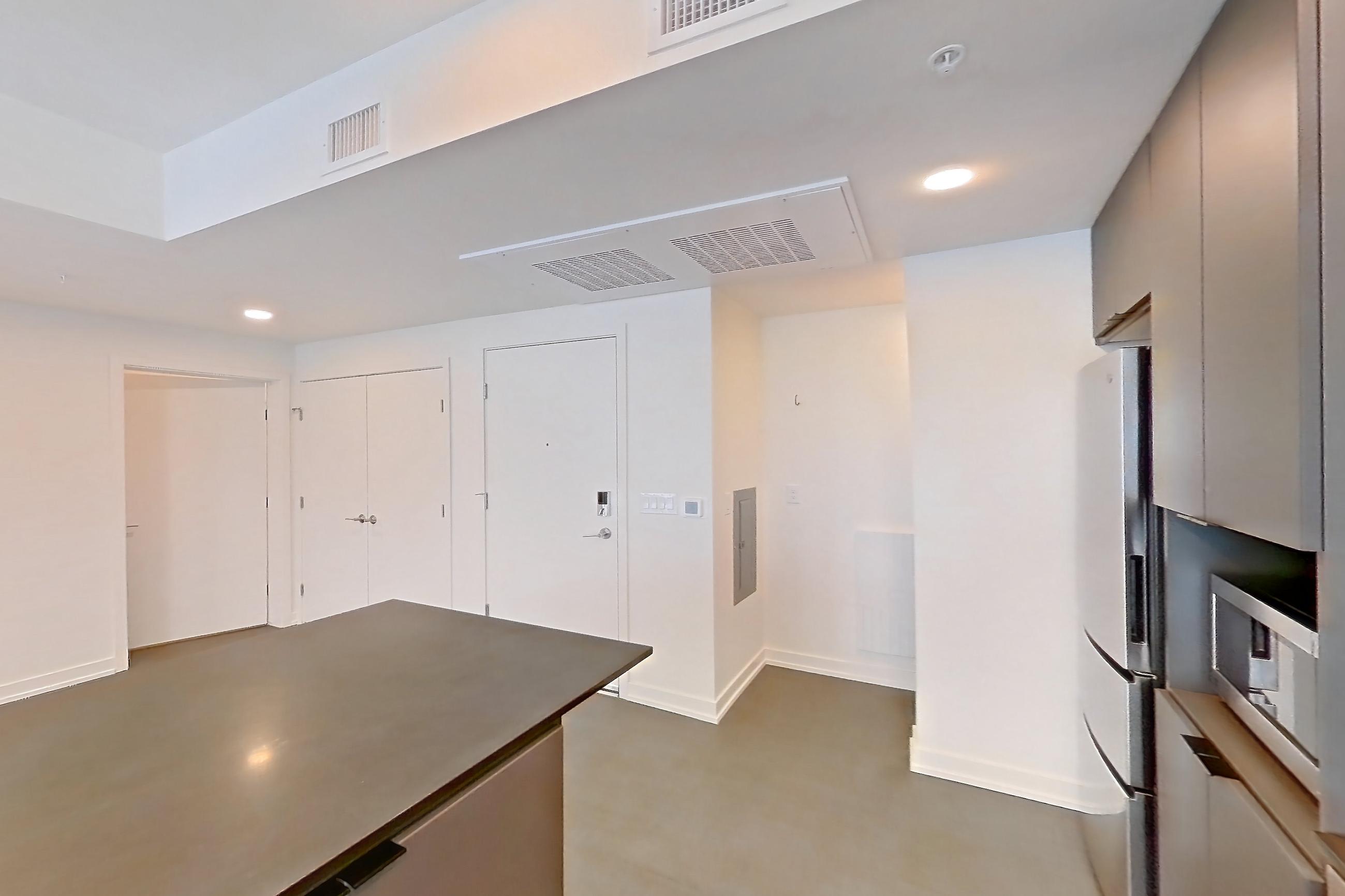 Kitchen with dark countertops, dishwasher, electric range, light carpet, microwave, oven/range, refrigerator, stainless steel appliances, and white appliances, Apartment 3031 at Dwell @ 5th and Farmer