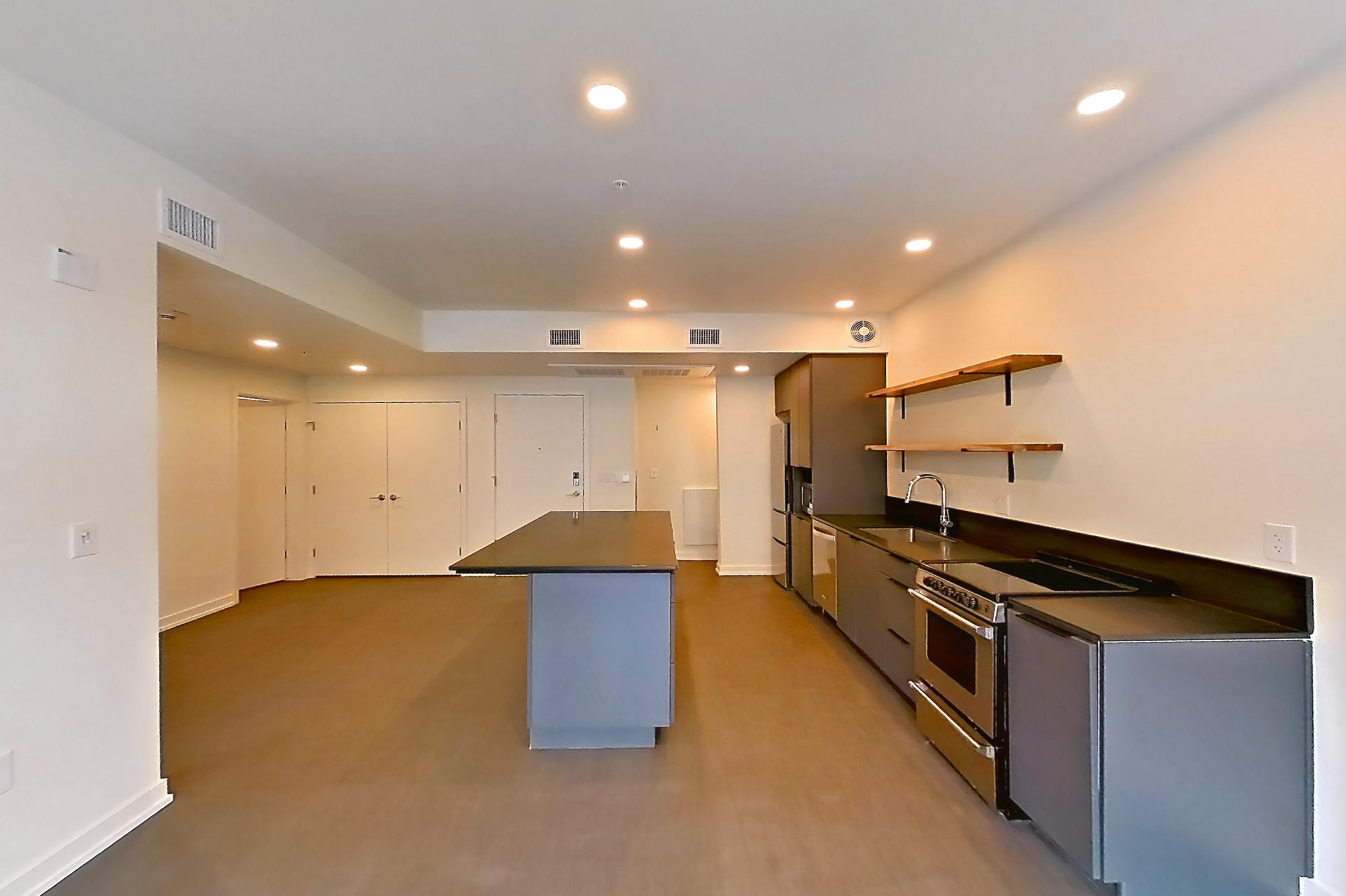 Living room with dark countertops, dishwasher, oven/range, refrigerator, and stainless steel appliances, Apartment 3031 at Dwell @ 5th and Farmer