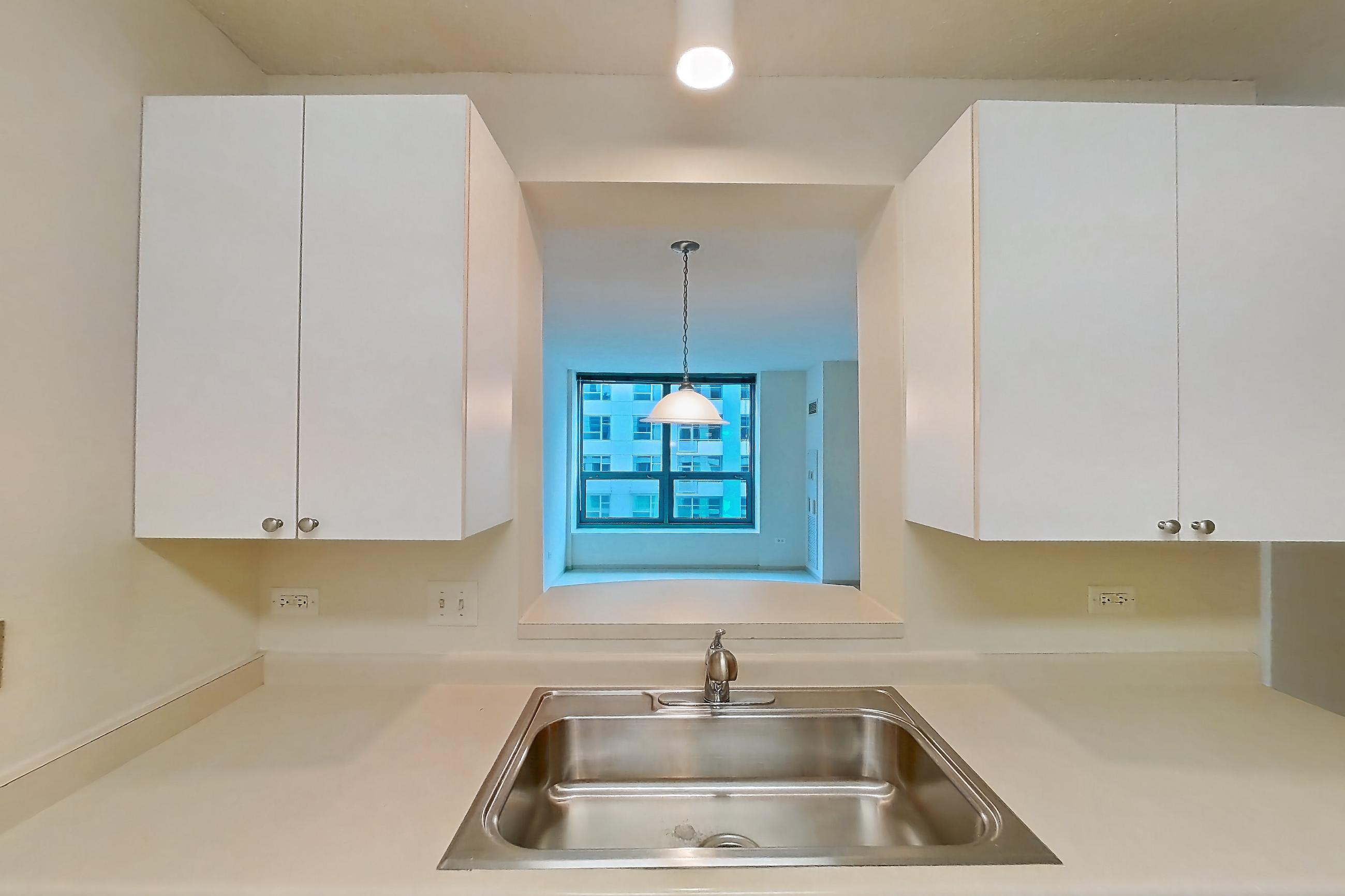 Kitchen with dishwasher, electric range, light countertops, light vinyl flooring, microwave, oven/range, and white appliances, Apartment 802 at Sky55