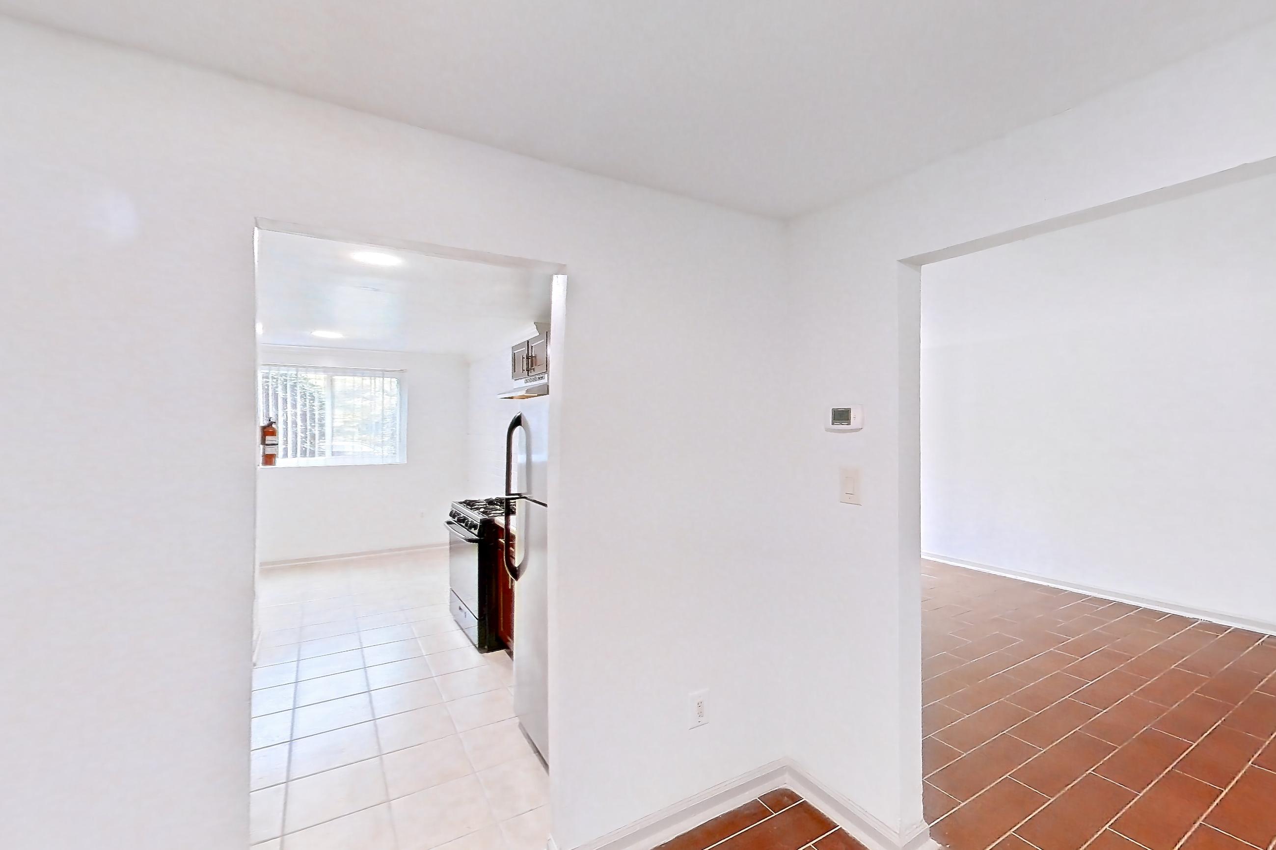 Dining room with dark wood-finish flooring, gas range, light tile flooring, refrigerator, white appliances, and wood-look tile flooring, Apartment 9318ER14 at Franklin Park at Greenbelt Station