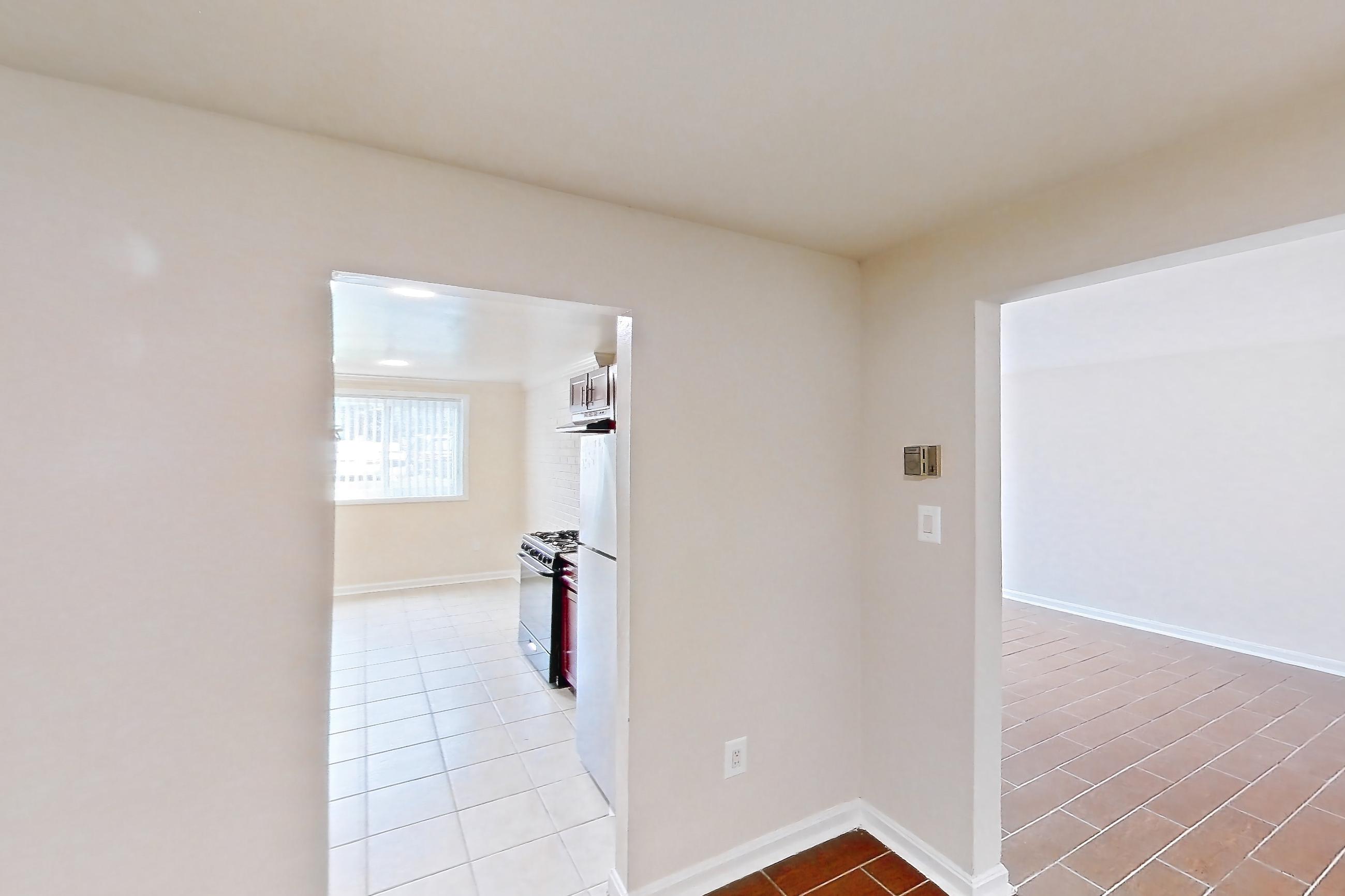 Dining room with dark wood-finish flooring, gas range, light tile flooring, refrigerator, white appliances, and wood-look tile flooring, Apartment 9340ER14 at Franklin Park at Greenbelt Station