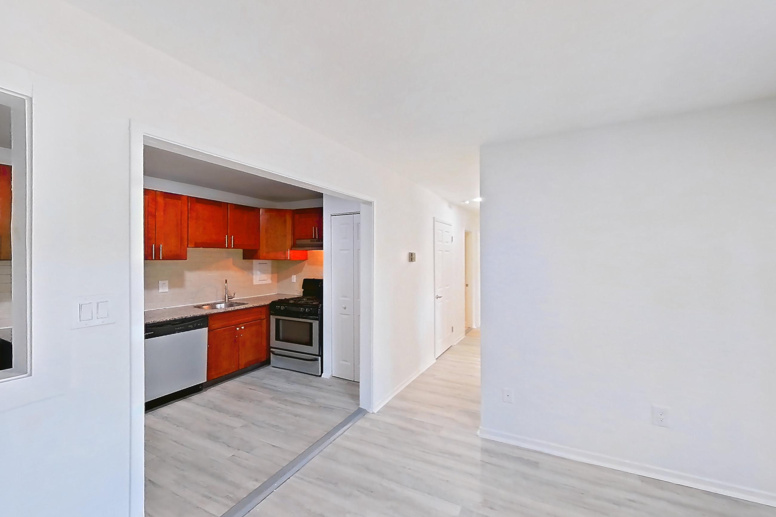 Living room with light countertops and light wood-finish flooring, Apartment 6120BD34 at Franklin Park at Greenbelt Station