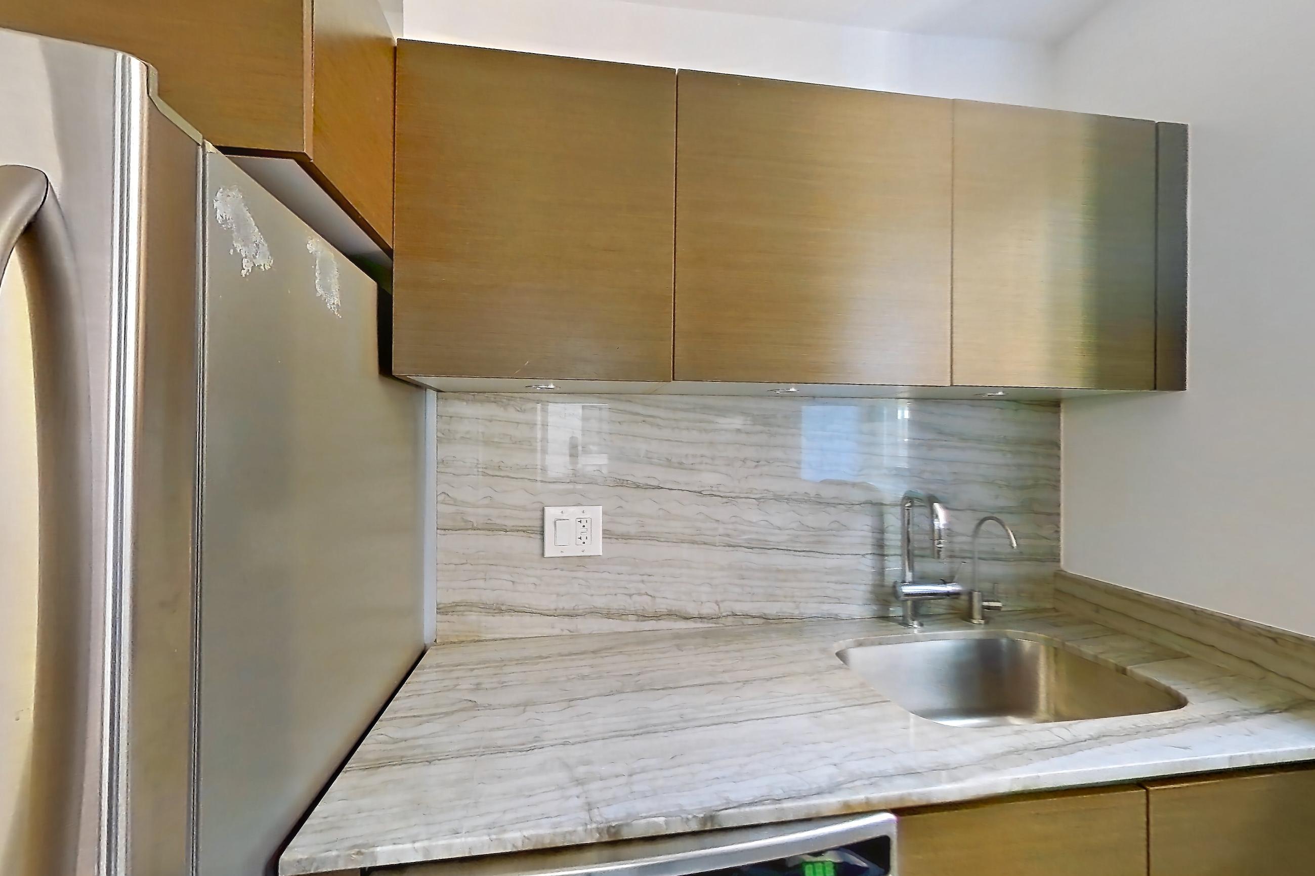 Kitchen with dishwasher, gas range, light countertops, light stone countertops, light tile flooring, microwave, oven/range, and stainless steel appliances, Apartment 10M at Stonehenge Leasing