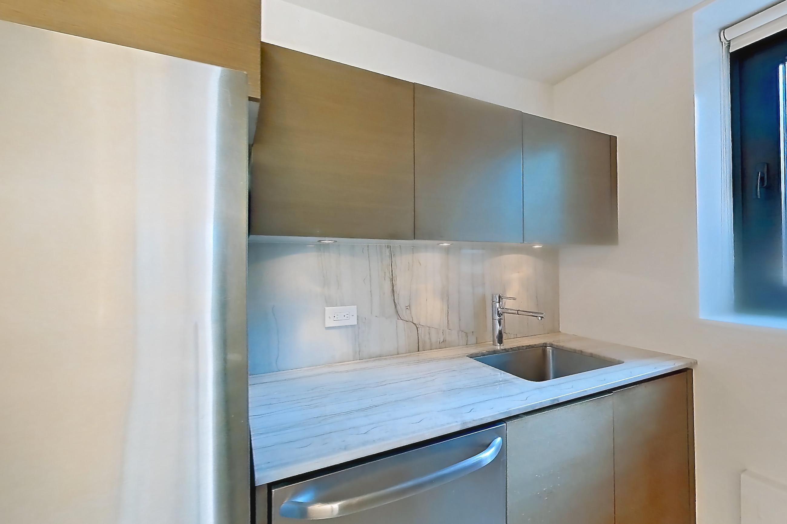 Kitchen with dishwasher, gas range, light countertops, light stone countertops, light tile flooring, oven/range, and stainless steel appliances, Apartment 22C at Stonehenge Leasing
