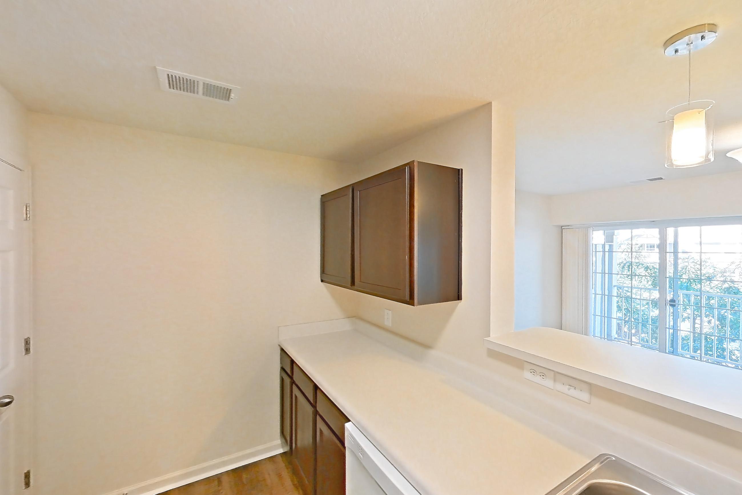 Kitchen with dark carpet, dark wood-finish flooring, dishwasher, electric range, light countertops, oven/range, range hood, refrigerator, and white appliances, Apartment 6421-206 at Ashley Estates