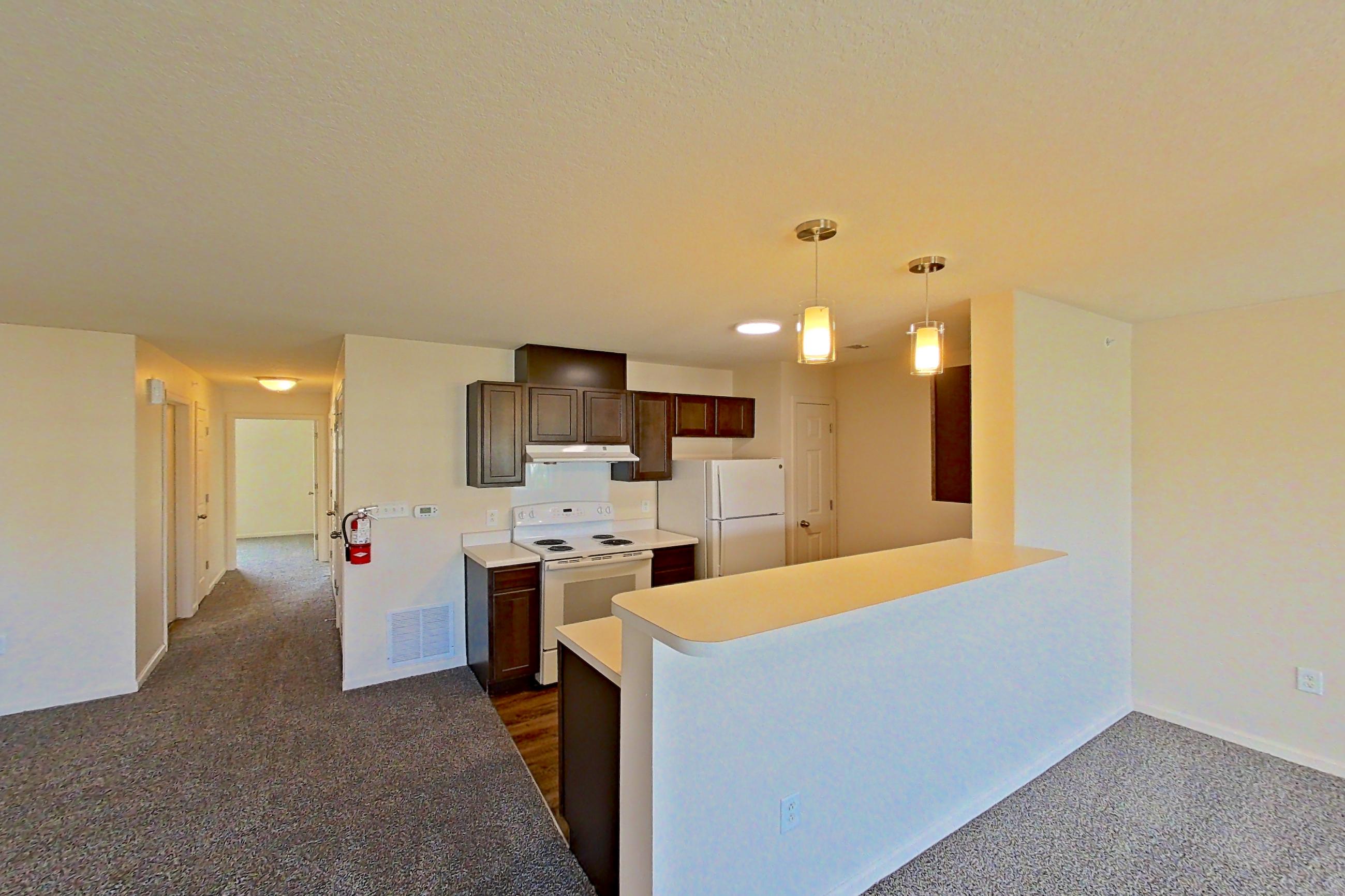 Living space with dark carpet, electric range, light countertops, oven/range, refrigerator, and white appliances, Apartment 6421-206 at Ashley Estates