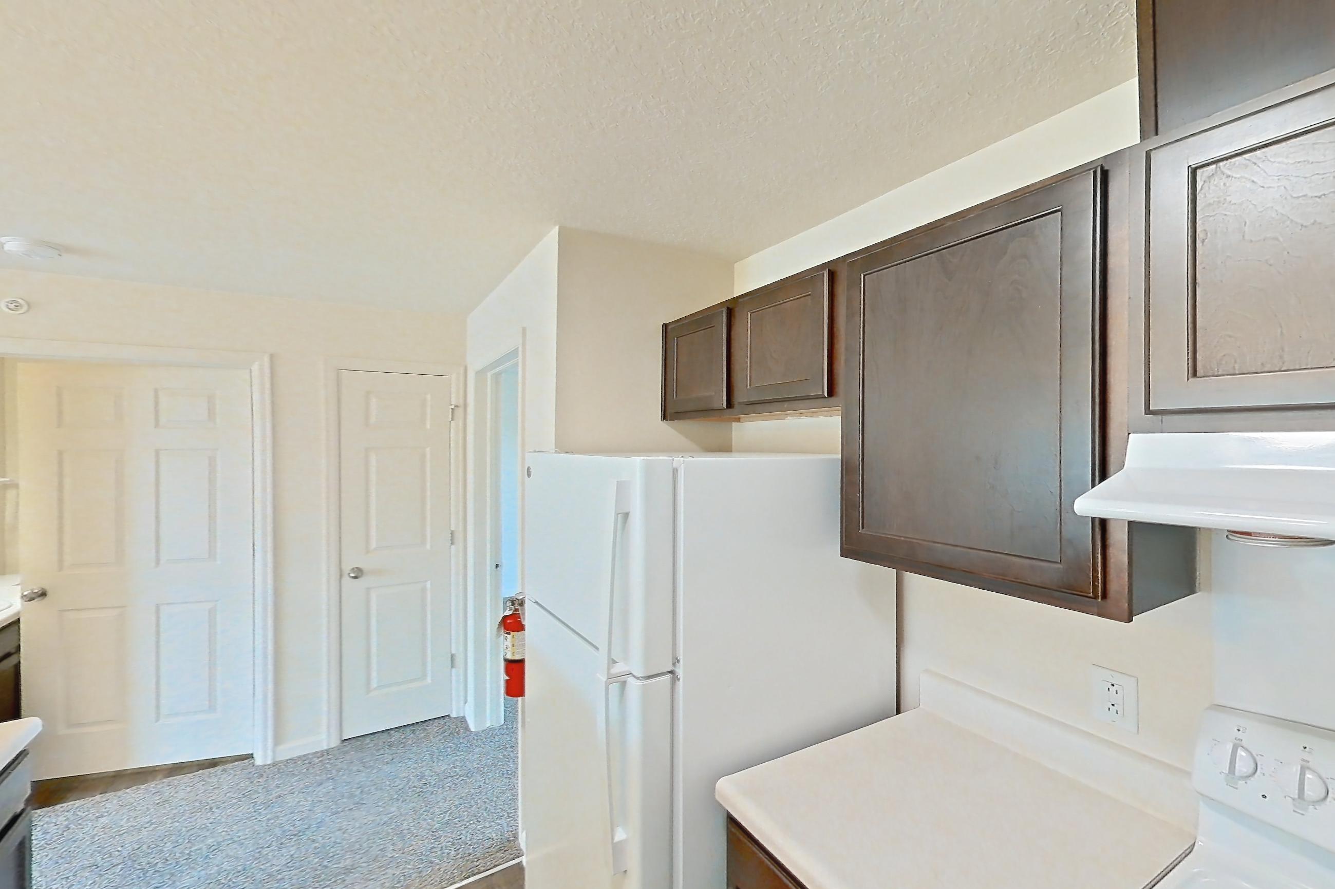 Kitchen with dark wood-finish flooring, dishwasher, electric range, light countertops, oven/range, refrigerator, and white appliances, Apartment 6469-206 at Ashley Estates