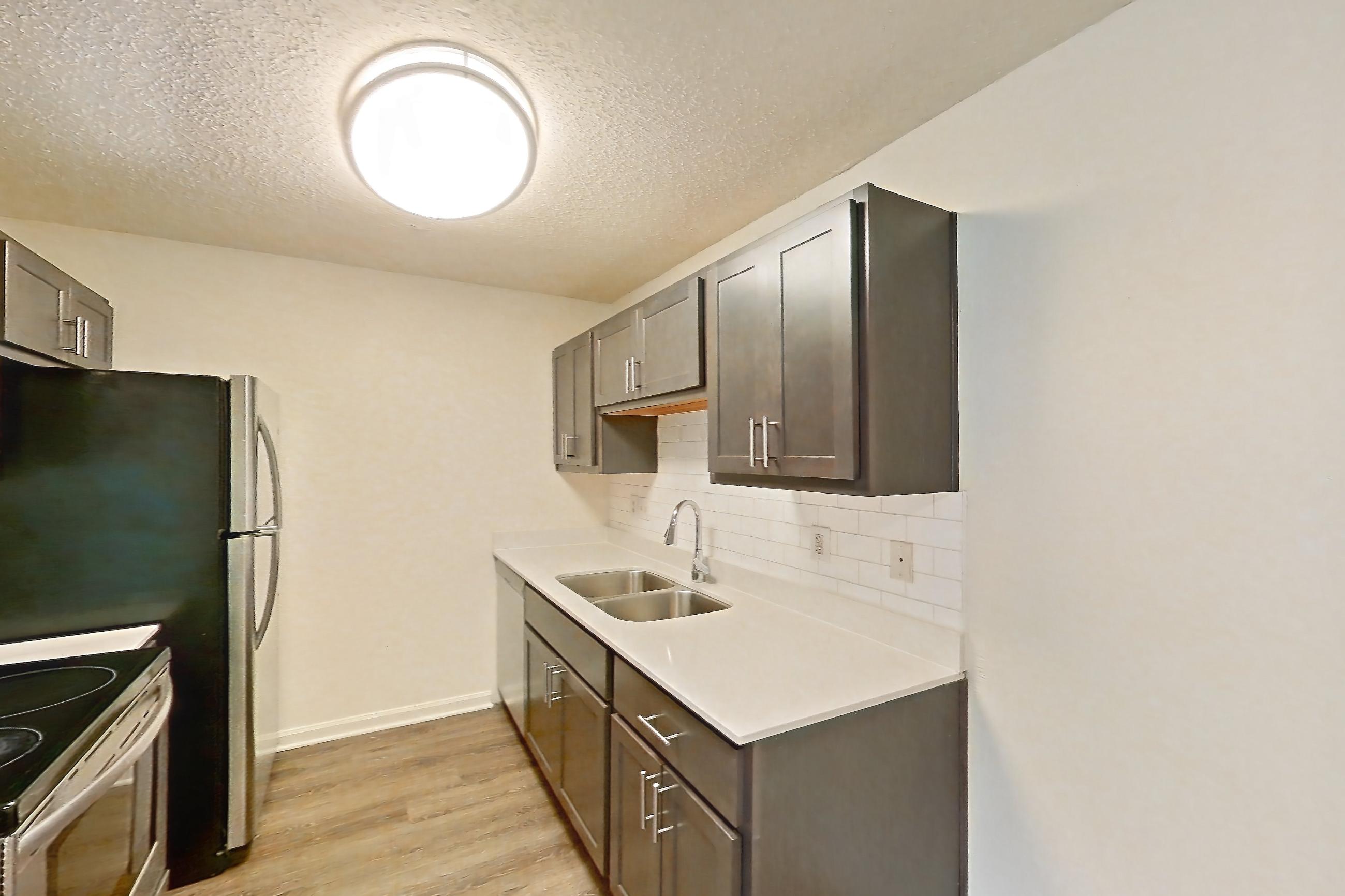 Dining room with electric range, fireplace, light carpet, light countertops, light stone countertops, light wood-finish flooring, oven/range, and stainless steel appliances, Apartment 61302 at The Boulders