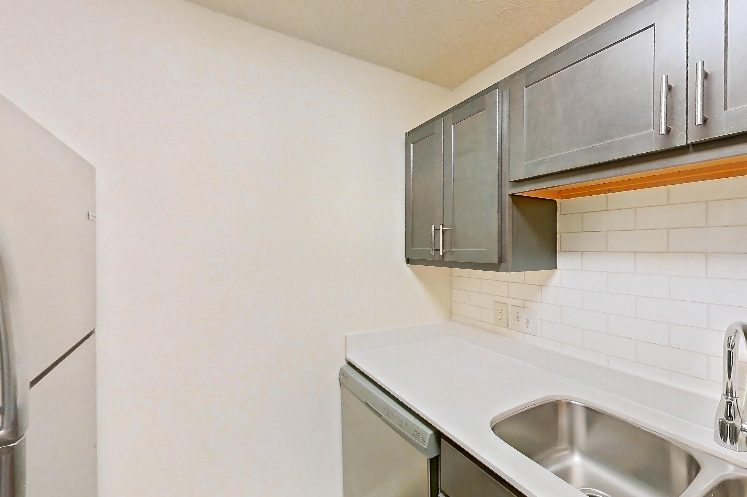 Kitchen with dishwasher, electric range, light stone countertops, light wood-finish flooring, oven/range, refrigerator, and stainless steel appliances, Apartment 68104 at The Boulders