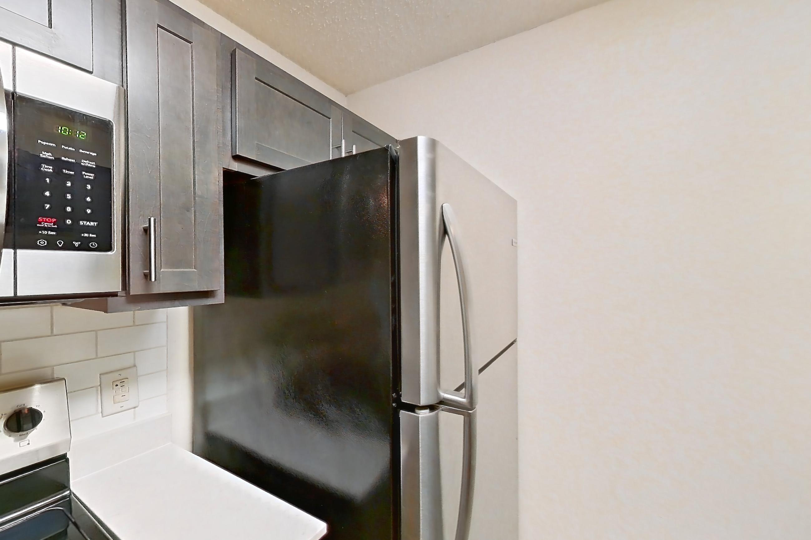 Kitchen with dishwasher, electric range, light stone countertops, light wood-finish flooring, oven/range, refrigerator, and stainless steel appliances, Apartment 68104 at The Boulders
