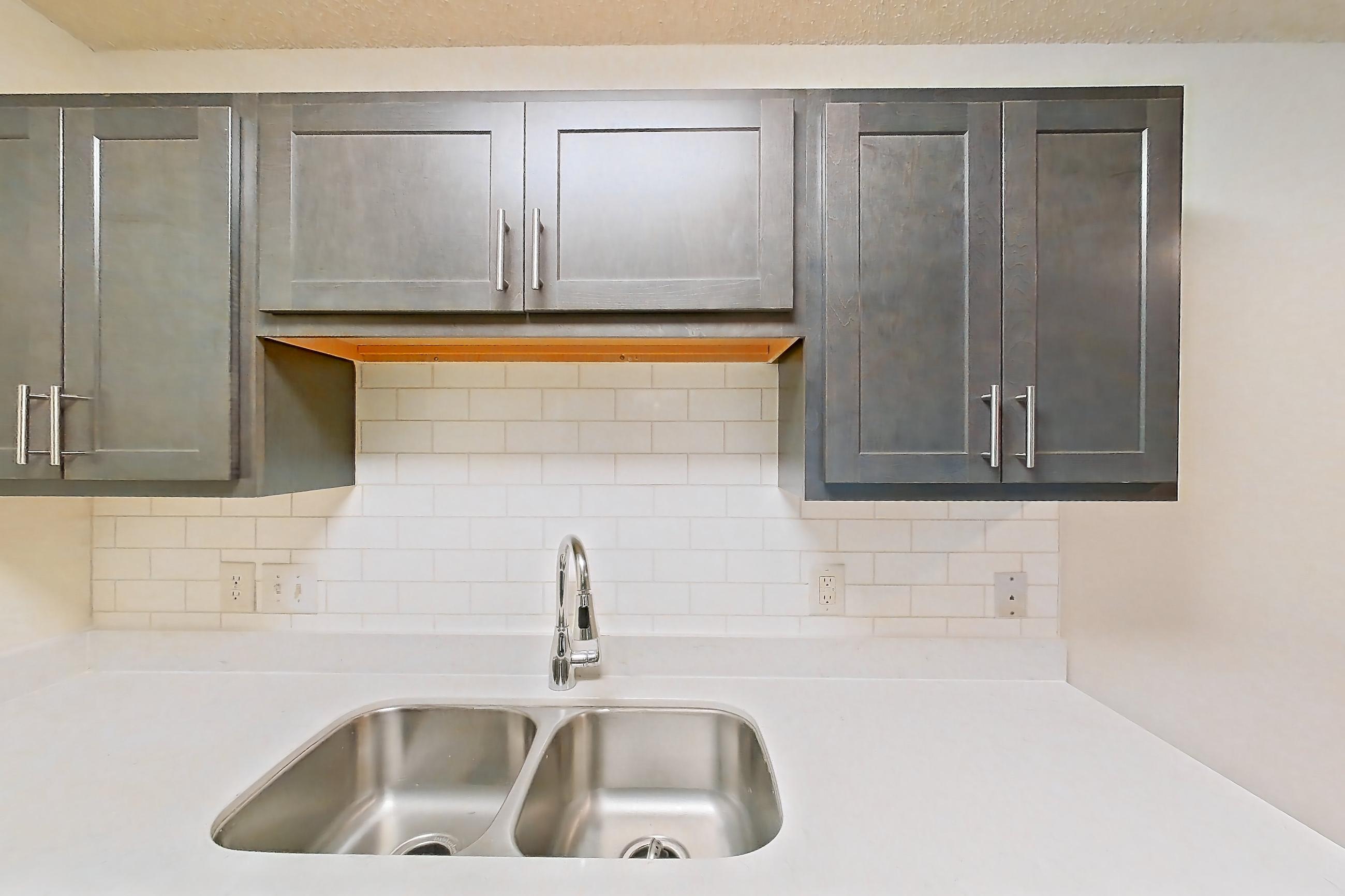 Kitchen with dishwasher, electric range, light stone countertops, light wood-finish flooring, oven/range, refrigerator, and stainless steel appliances, Apartment 68104 at The Boulders