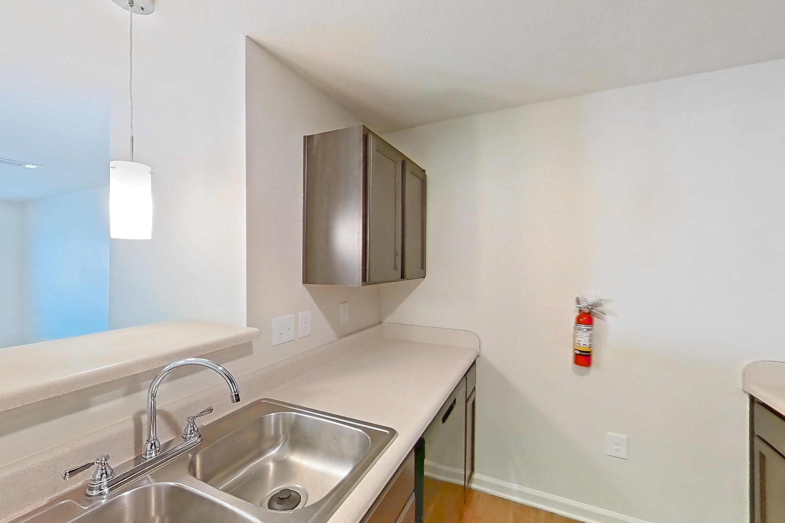 Kitchen with black appliances, dark wood-finish flooring, electric range, light countertops, light wood-finish flooring, and oven/range, Apartment 8212 Unit 308 at The HUB on Harris