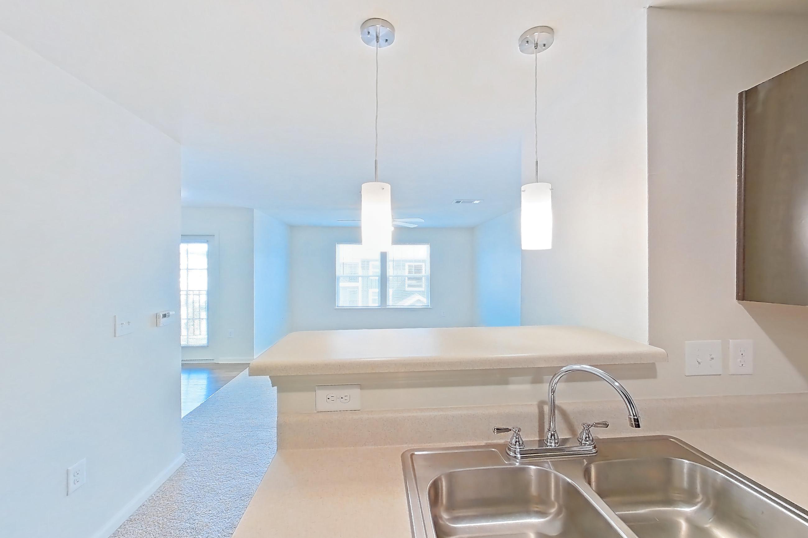Kitchen with black appliances, dark wood-finish flooring, electric range, light countertops, light wood-finish flooring, and oven/range, Apartment 8212 Unit 308 at The HUB on Harris