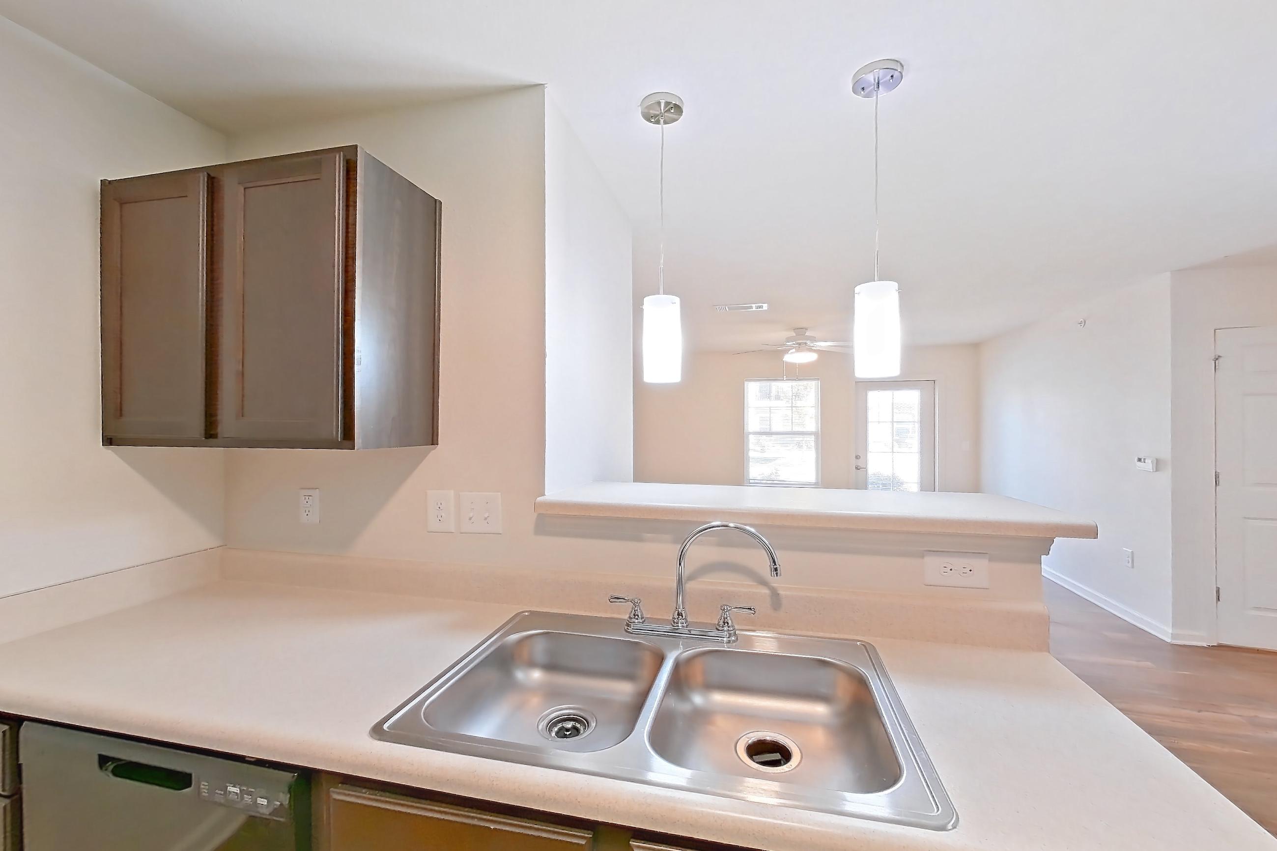 Kitchen with black appliances, dishwasher, electric range, light countertops, light wood-finish flooring, oven/range, refrigerator, and stainless steel appliances, Apartment 8212 Unit 105 at The HUB on Harris