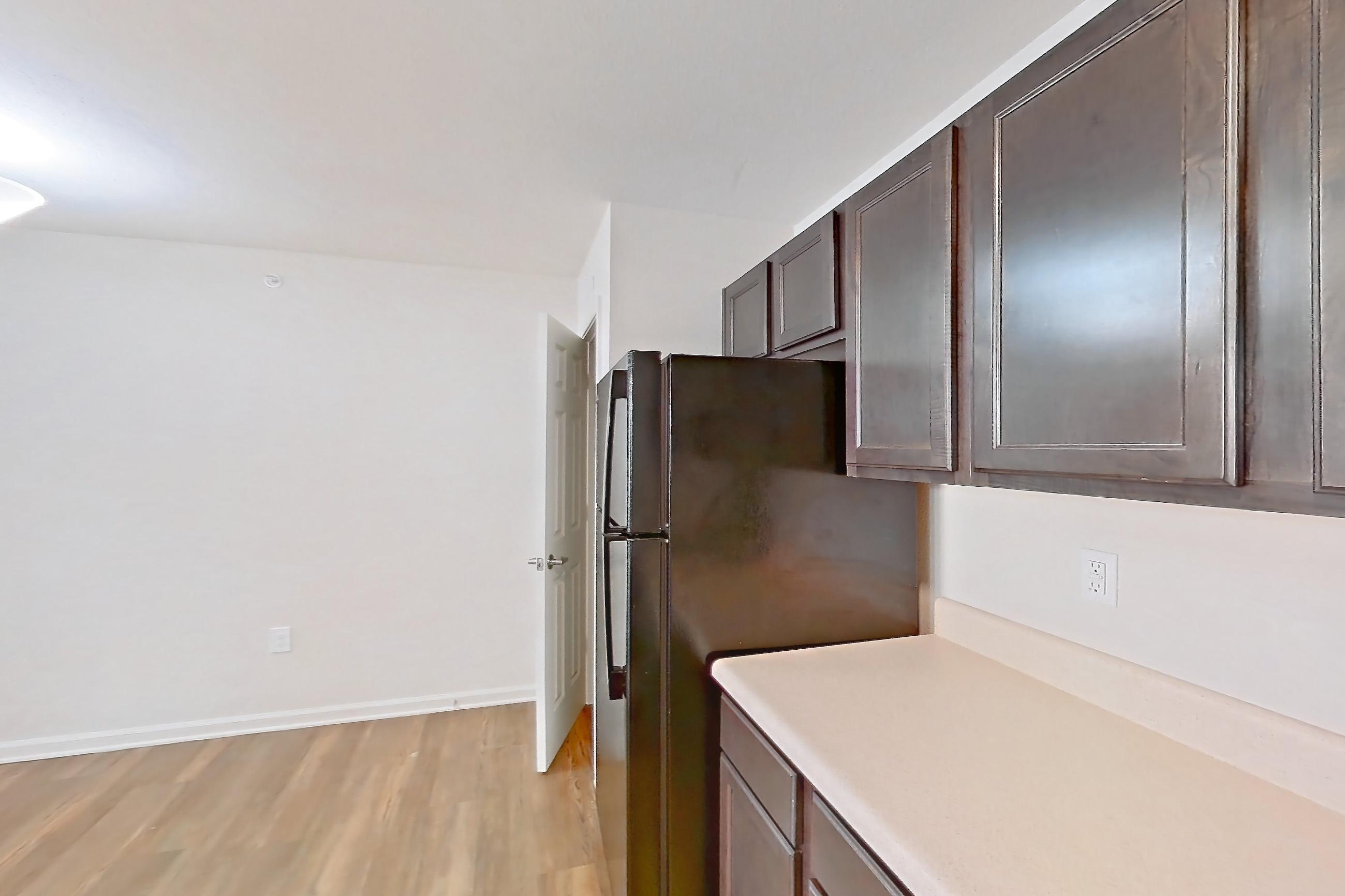 Kitchen with black appliances, dishwasher, electric range, light countertops, light wood-finish flooring, oven/range, refrigerator, and stainless steel appliances, Apartment 8212 Unit 105 at The HUB on Harris