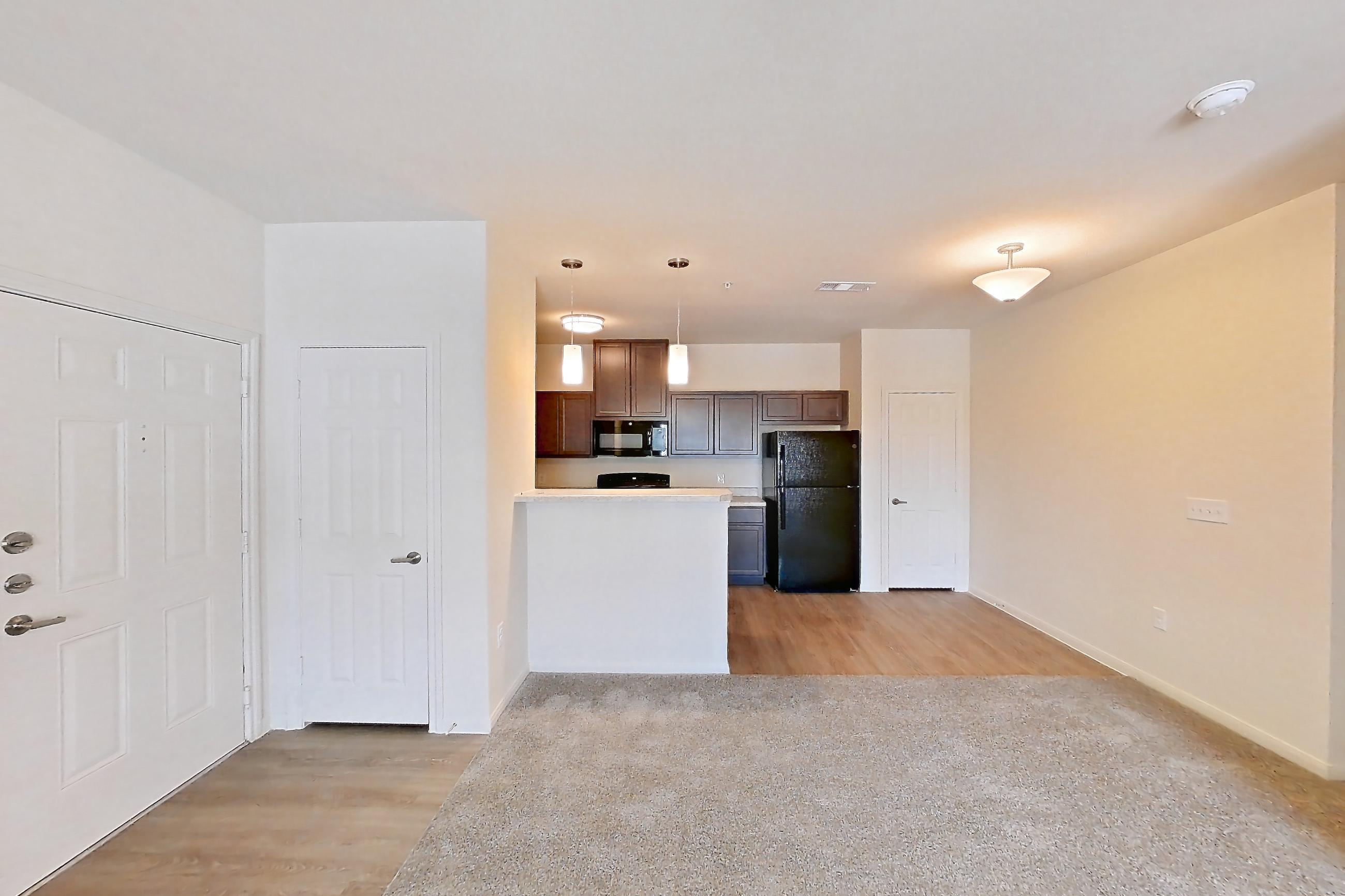 Living room with black appliances and refrigerator, Apartment 7208 at Mill Stream