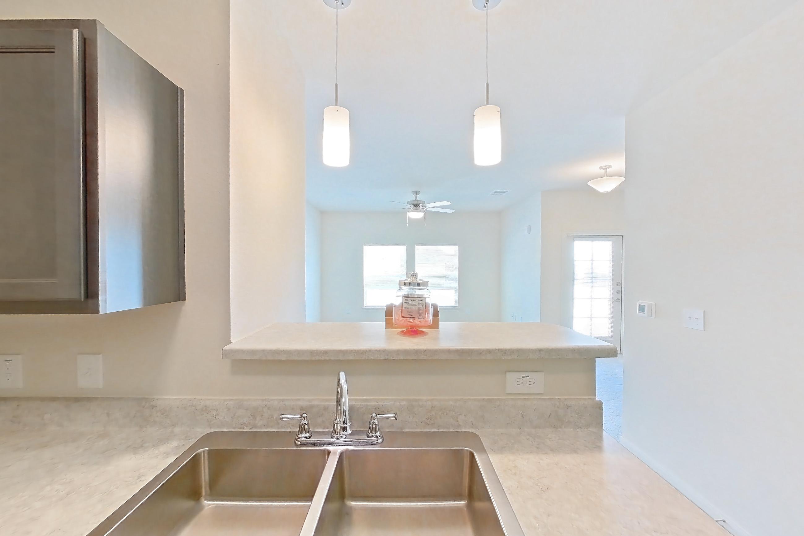 Kitchen with black appliances, dishwasher, electric range, light countertops, light wood-finish flooring, oven/range, refrigerator, and stainless steel appliances, Apartment 3101 at Mill Stream