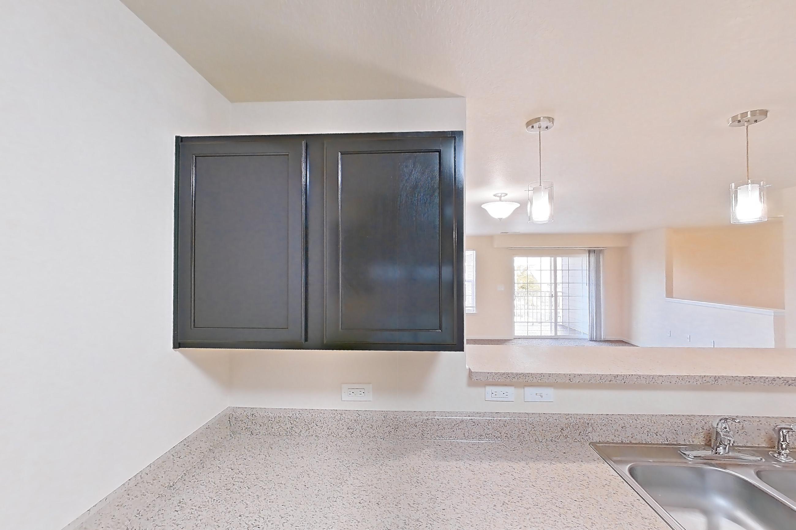 Kitchen with dark wood-finish flooring, dishwasher, electric range, light countertops, light stone countertops, oven/range, refrigerator, and white appliances, Apartment 19453 E 57th Ave - Unit 202 at The Meadows at Dunkirk