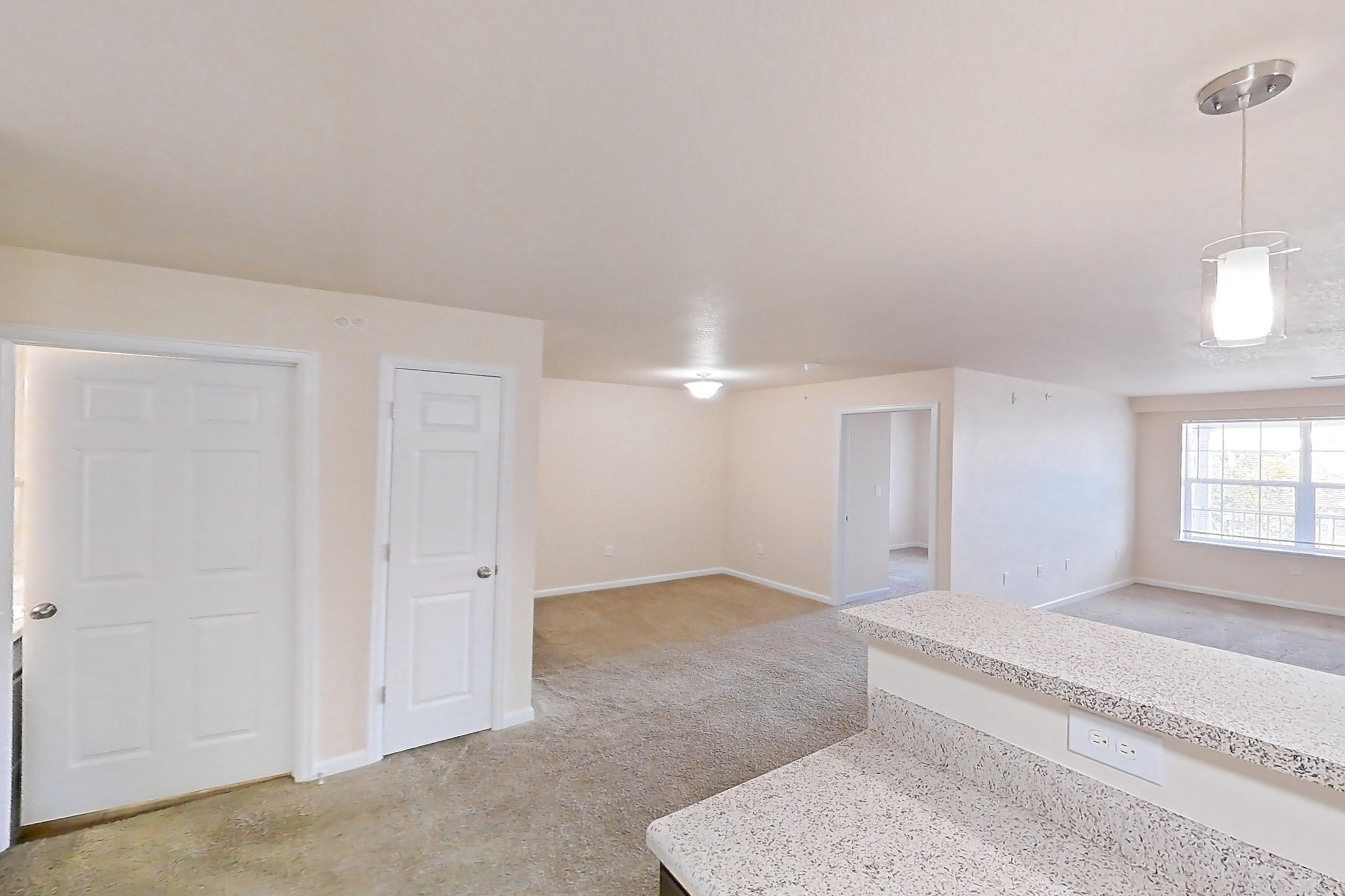 Kitchen with dark carpet, dark wood-finish flooring, dishwasher, electric range, light stone countertops, oven/range, refrigerator, and white appliances, Apartment 19400 E 57th Ave - Unit 204 at The Meadows at Dunkirk