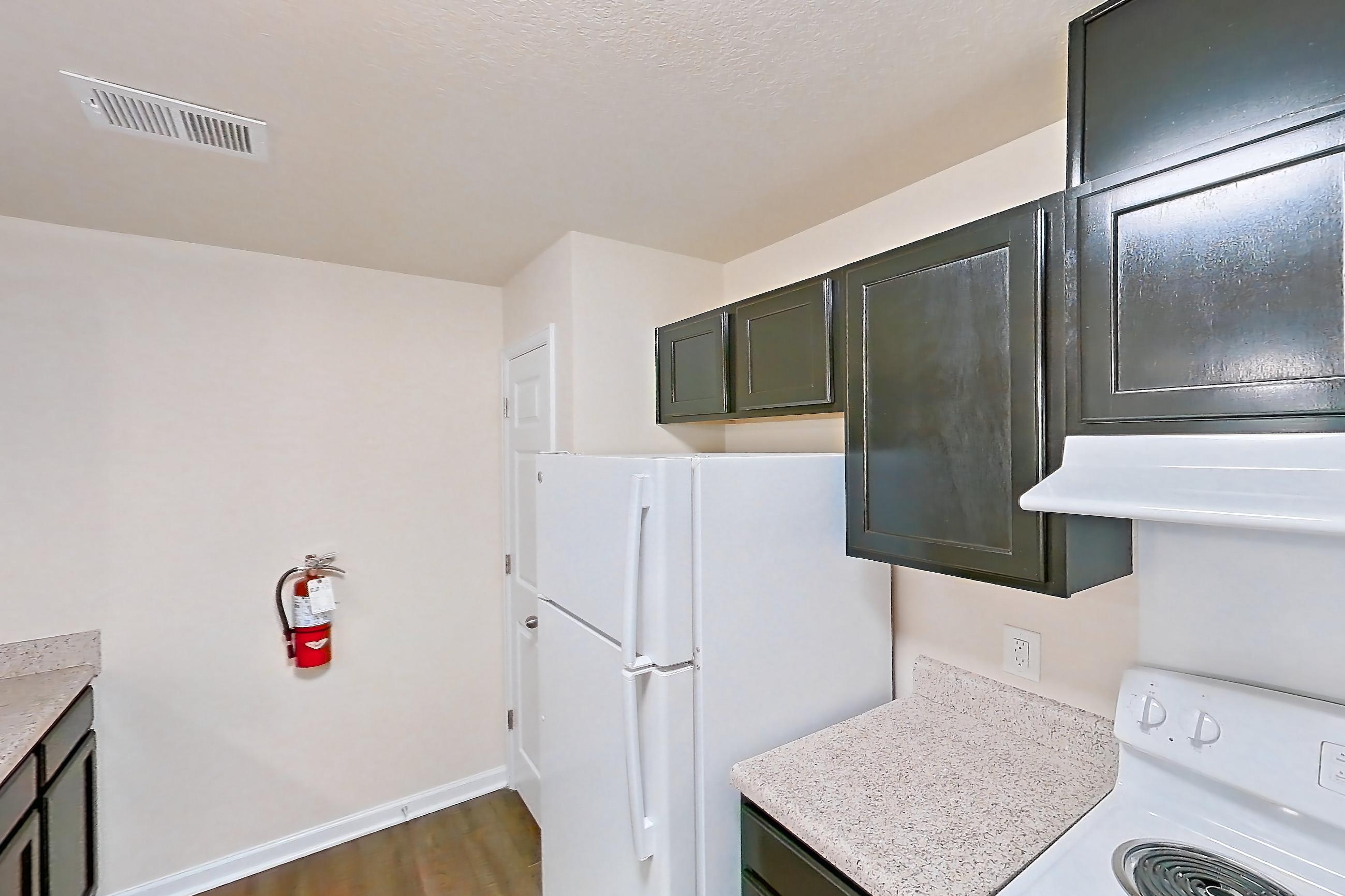 Kitchen with dark carpet, dark wood-finish flooring, dishwasher, electric range, light stone countertops, oven/range, refrigerator, and white appliances, Apartment 19400 E 57th Ave - Unit 204 at The Meadows at Dunkirk