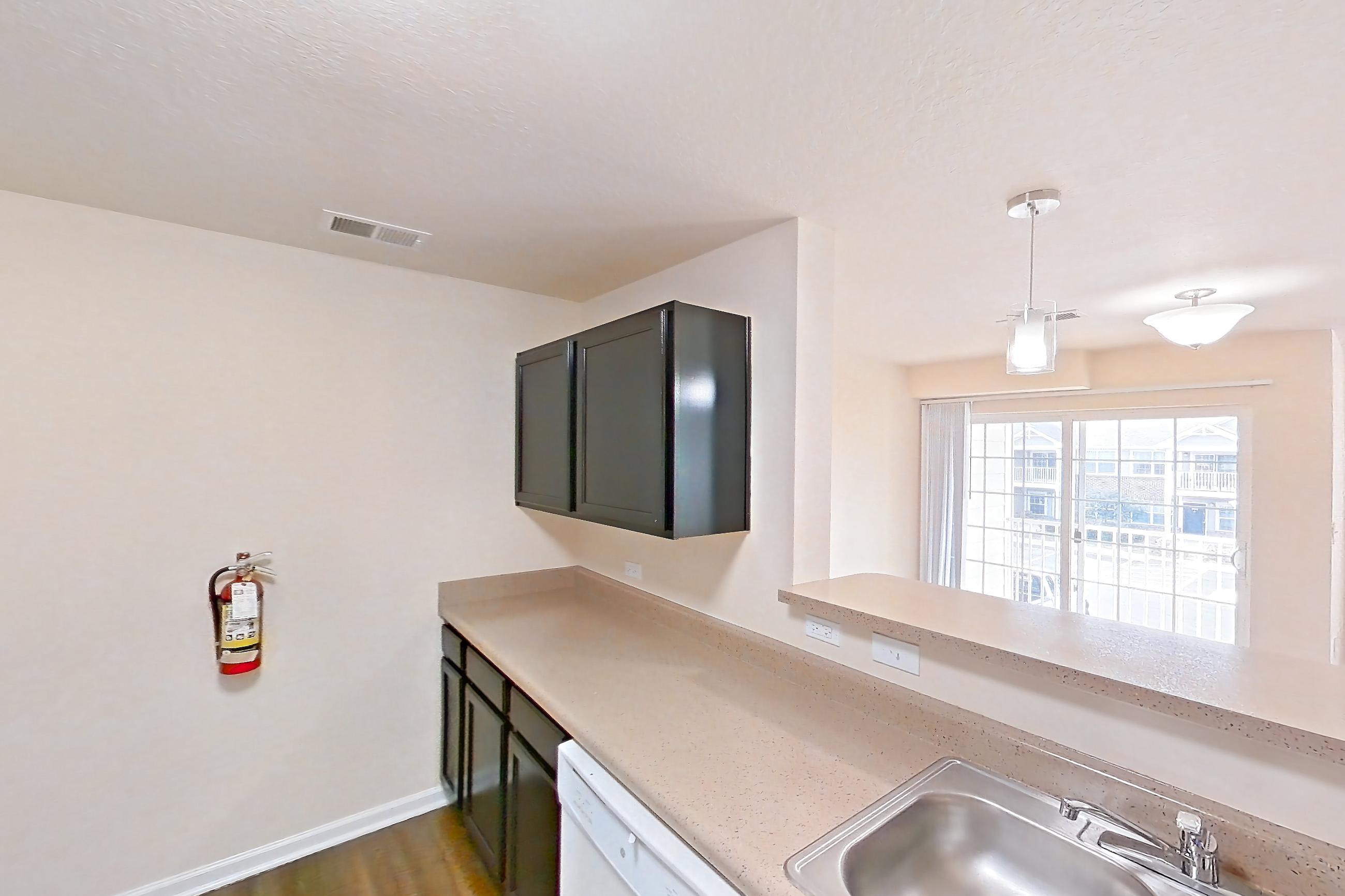 Kitchen with dark wood-finish flooring, dishwasher, electric range, light countertops, oven/range, refrigerator, and white appliances, Apartment 19573 E 57th Ave - Unit 204 at The Meadows at Dunkirk