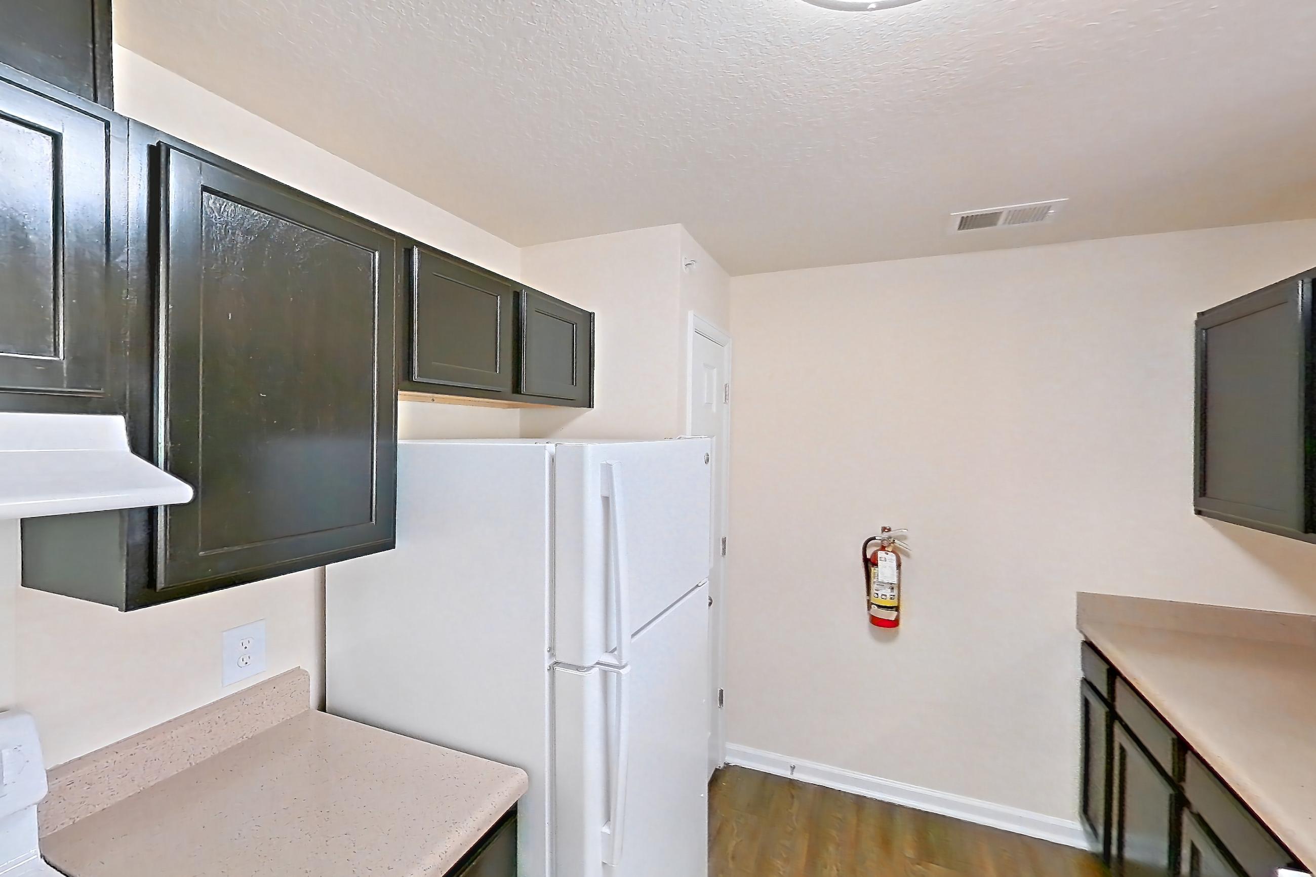 Kitchen with dark wood-finish flooring, dishwasher, electric range, light countertops, oven/range, refrigerator, and white appliances, Apartment 19573 E 57th Ave - Unit 204 at The Meadows at Dunkirk