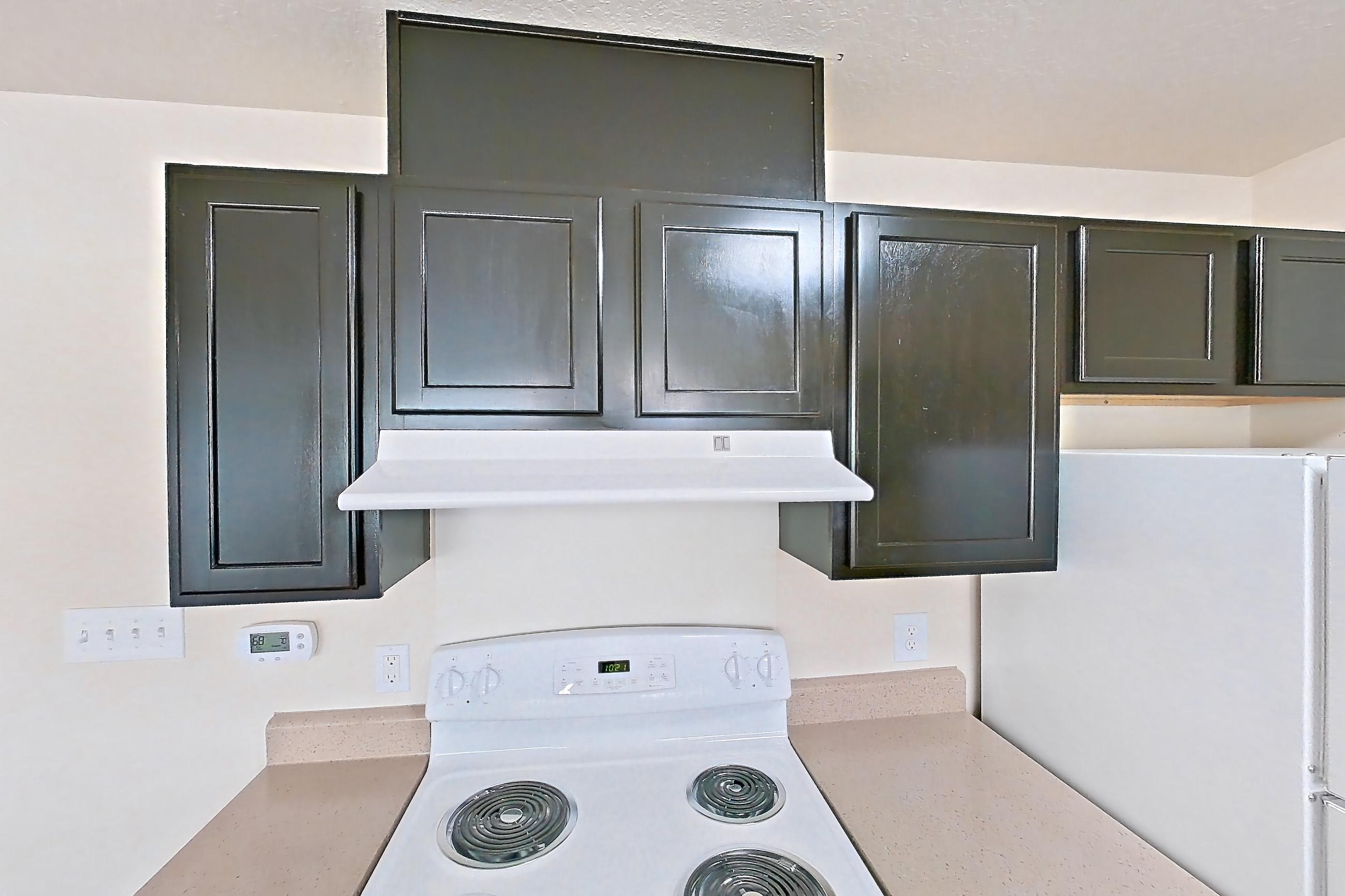 Kitchen with dark wood-finish flooring, dishwasher, electric range, light countertops, oven/range, refrigerator, and white appliances, Apartment 19573 E 57th Ave - Unit 204 at The Meadows at Dunkirk