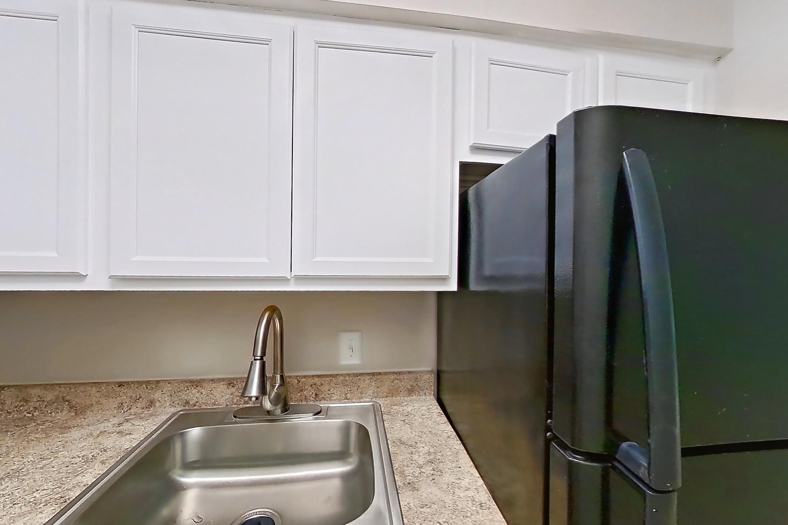 Kitchen with black appliances, electric range, light countertops, light tile flooring, oven/range, and refrigerator, Apartment 113 at Palm Villas