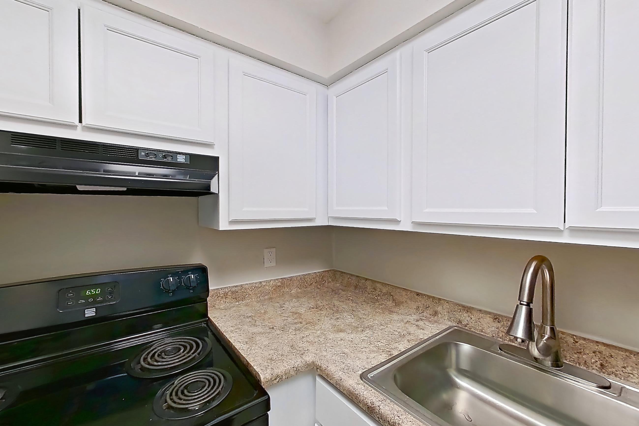 Kitchen with black appliances, electric range, light countertops, light tile flooring, oven/range, and refrigerator, Apartment 113 at Palm Villas
