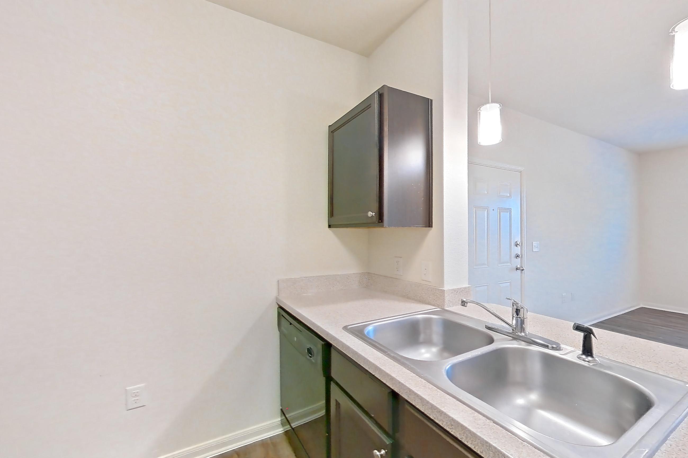 Kitchen with black appliances, dark wood-finish flooring, dishwasher, electric range, light countertops, oven/range, refrigerator, and stainless steel appliances, Apartment 1314 at The Heights on Parmer