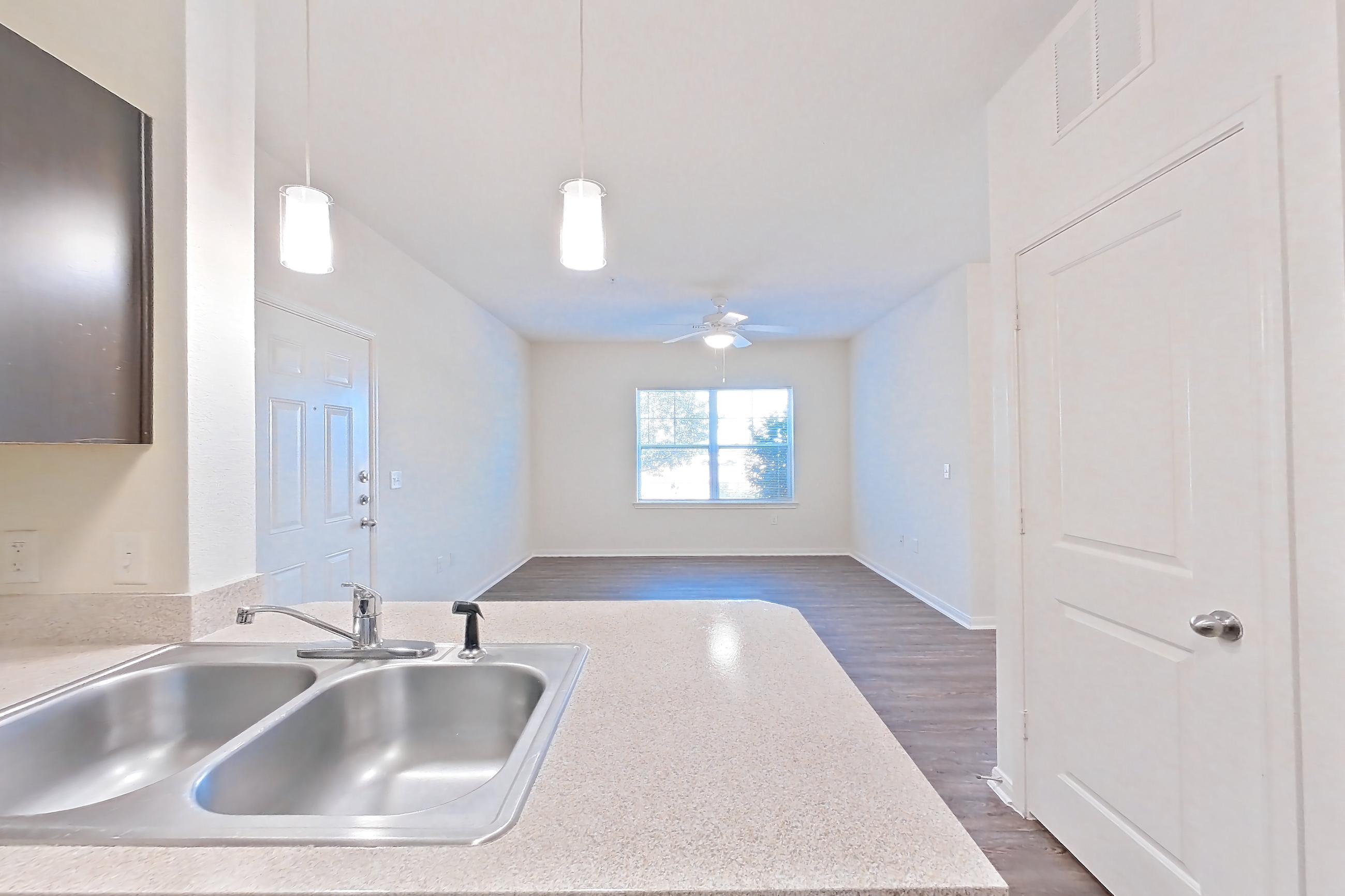 Kitchen with black appliances, dark wood-finish flooring, dishwasher, electric range, light countertops, oven/range, refrigerator, and stainless steel appliances, Apartment 1314 at The Heights on Parmer