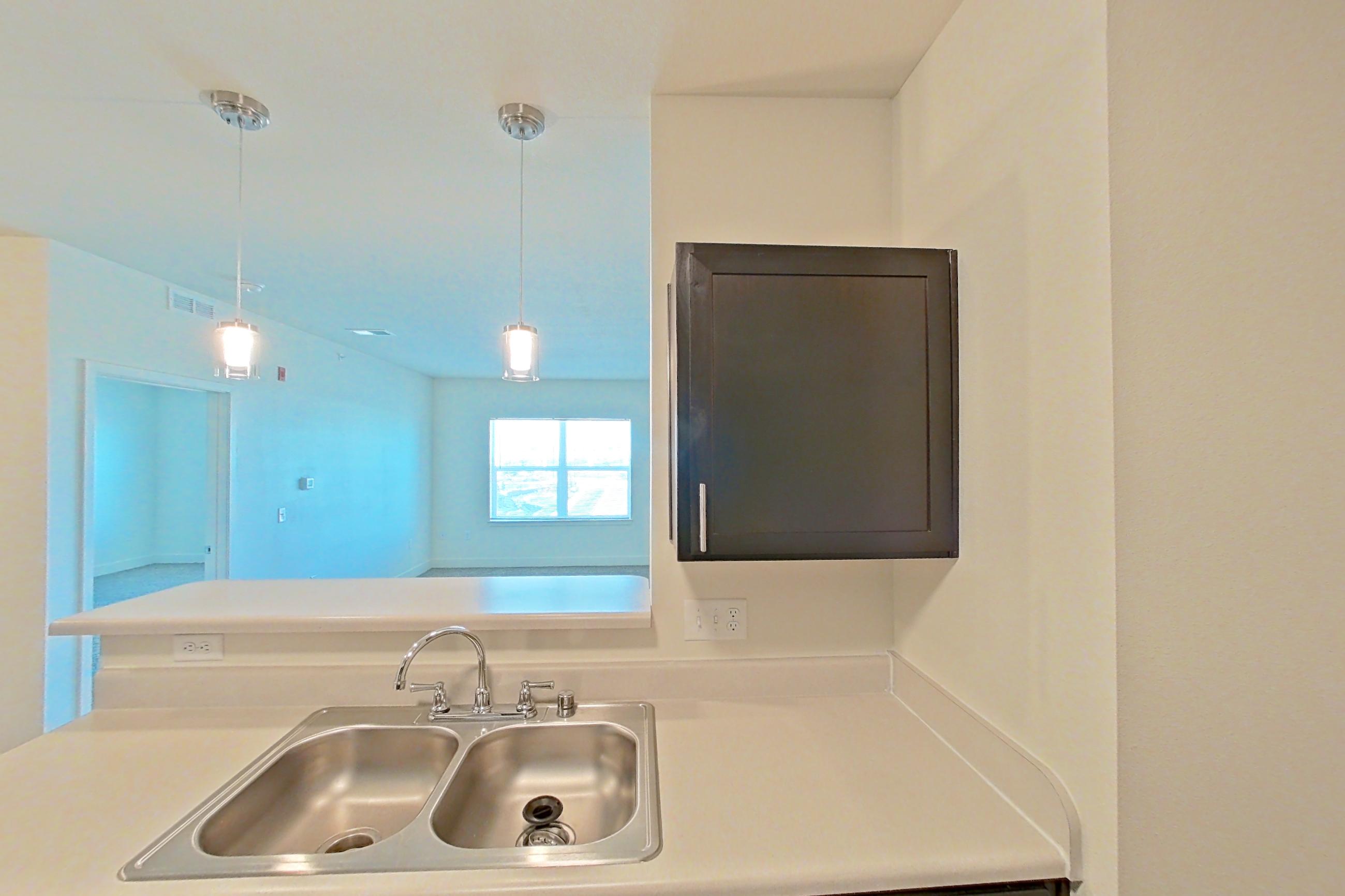 Kitchen with black appliances, dark wood-finish flooring, dishwasher, electric range, light countertops, oven/range, refrigerator, and stainless steel appliances, Apartment 4307 at Larkridge