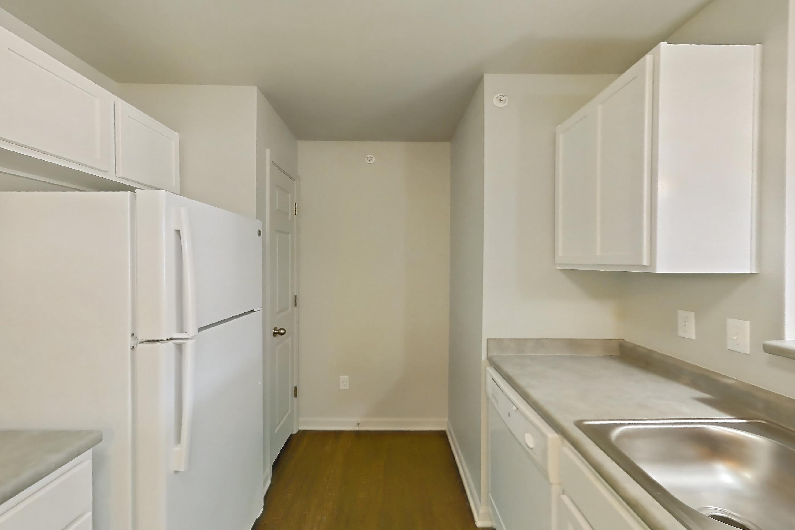 Kitchen with dark wood-finish flooring, dishwasher, electric range, light countertops, oven/range, refrigerator, and white appliances, Apartment 714 at Sunset View
