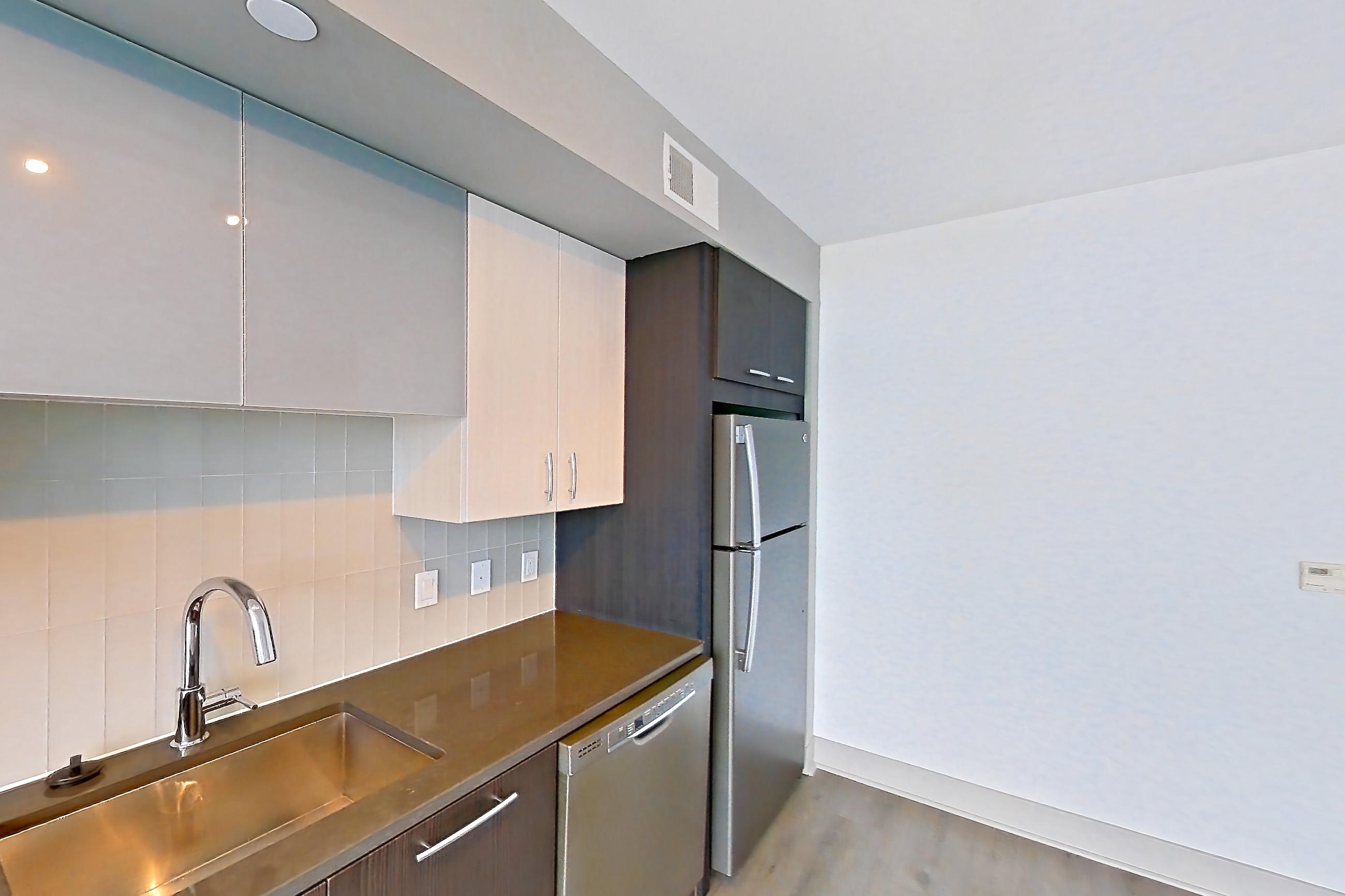 Kitchen with dark countertops, dishwasher, electric range, light wood-finish flooring, oven/range, and stainless steel appliances, Apartment 1108 at Adaire