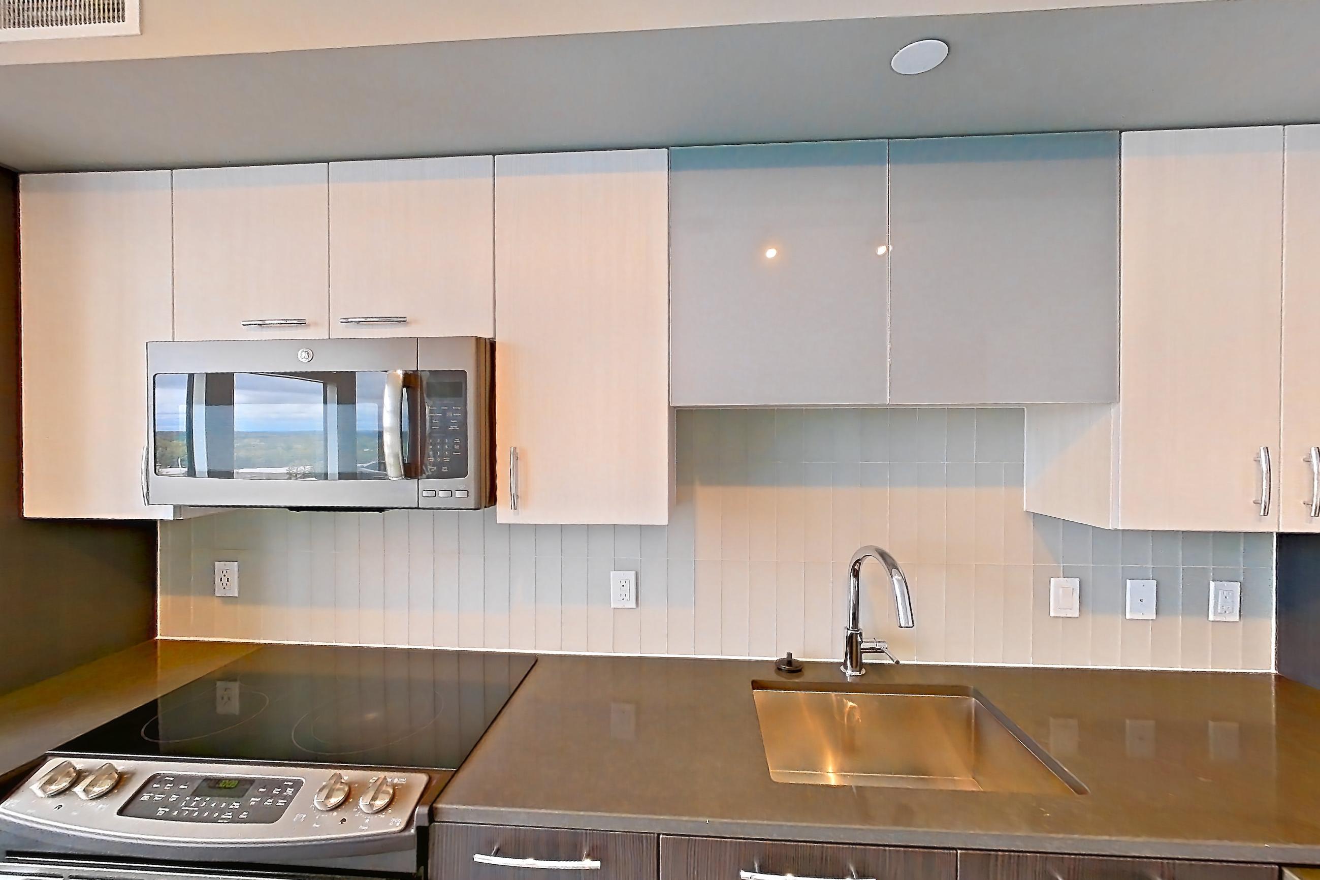 Kitchen with dark countertops, dishwasher, electric range, light wood-finish flooring, oven/range, and stainless steel appliances, Apartment 1108 at Adaire