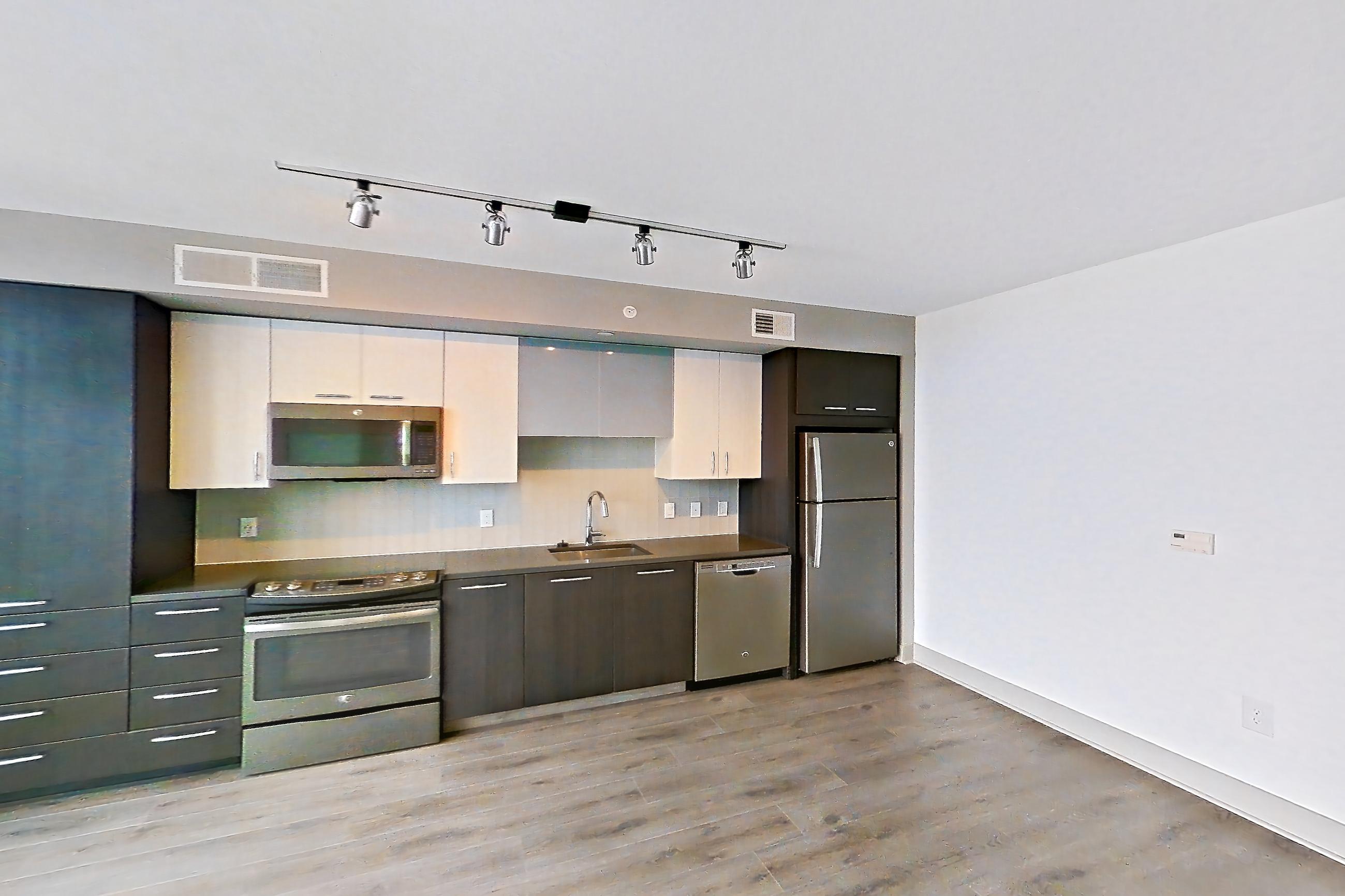 Living room with dark countertops, dishwasher, electric range, light wood-finish flooring, oven/range, refrigerator, and stainless steel appliances, Apartment 1108 at Adaire