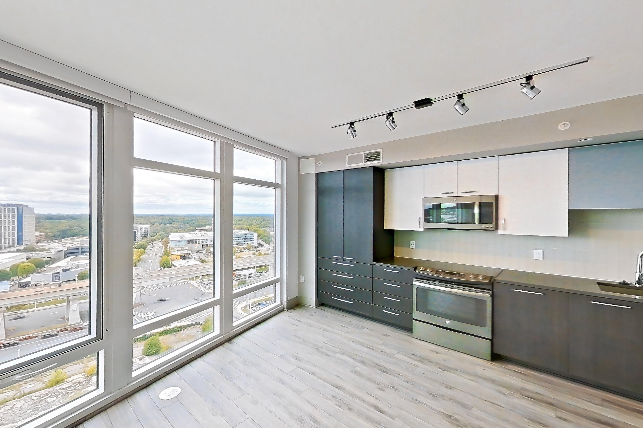 Living room with dark countertops, dishwasher, electric range, light wood-finish flooring, oven/range, refrigerator, and stainless steel appliances, Apartment 1811 at Adaire