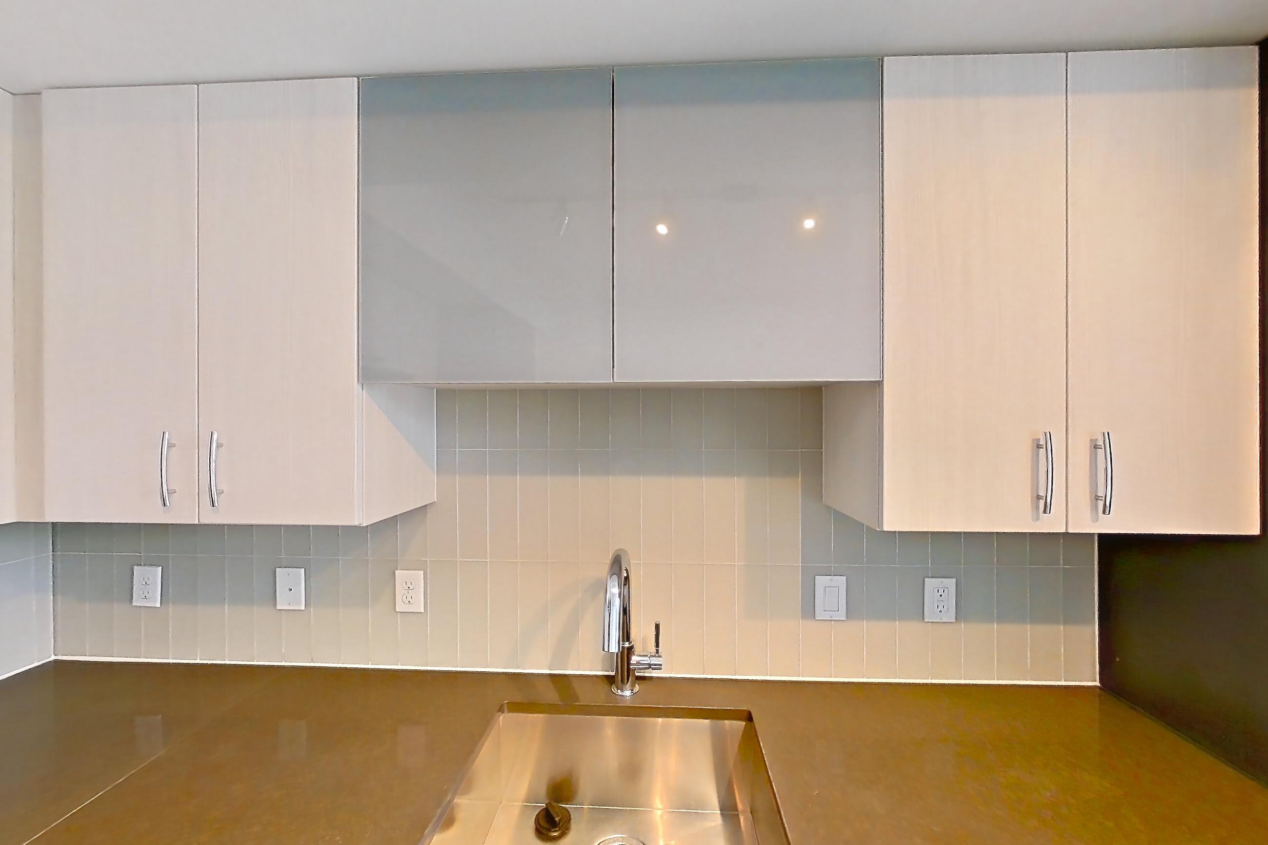 Kitchen with dark countertops, dark stone countertops, dishwasher, electric range, light wood-finish flooring, microwave, oven/range, refrigerator, stainless steel appliances, and white appliances, Apartment 1606 at Adaire